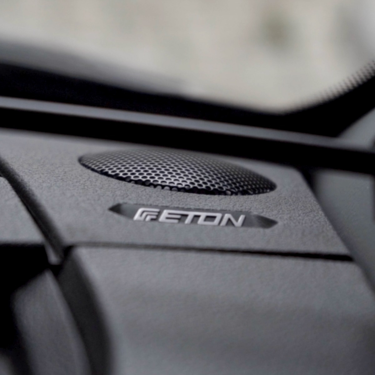 Ein Lautsprechergitter mit dem Schriftzug „GETON“ auf einem Armaturenbrett.