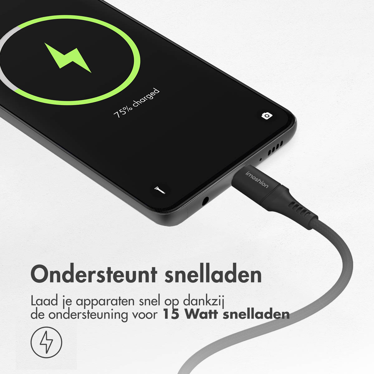 Un smartphone noir avec un câble de charge branché, affichant 75% de charge avec un éclair vert.