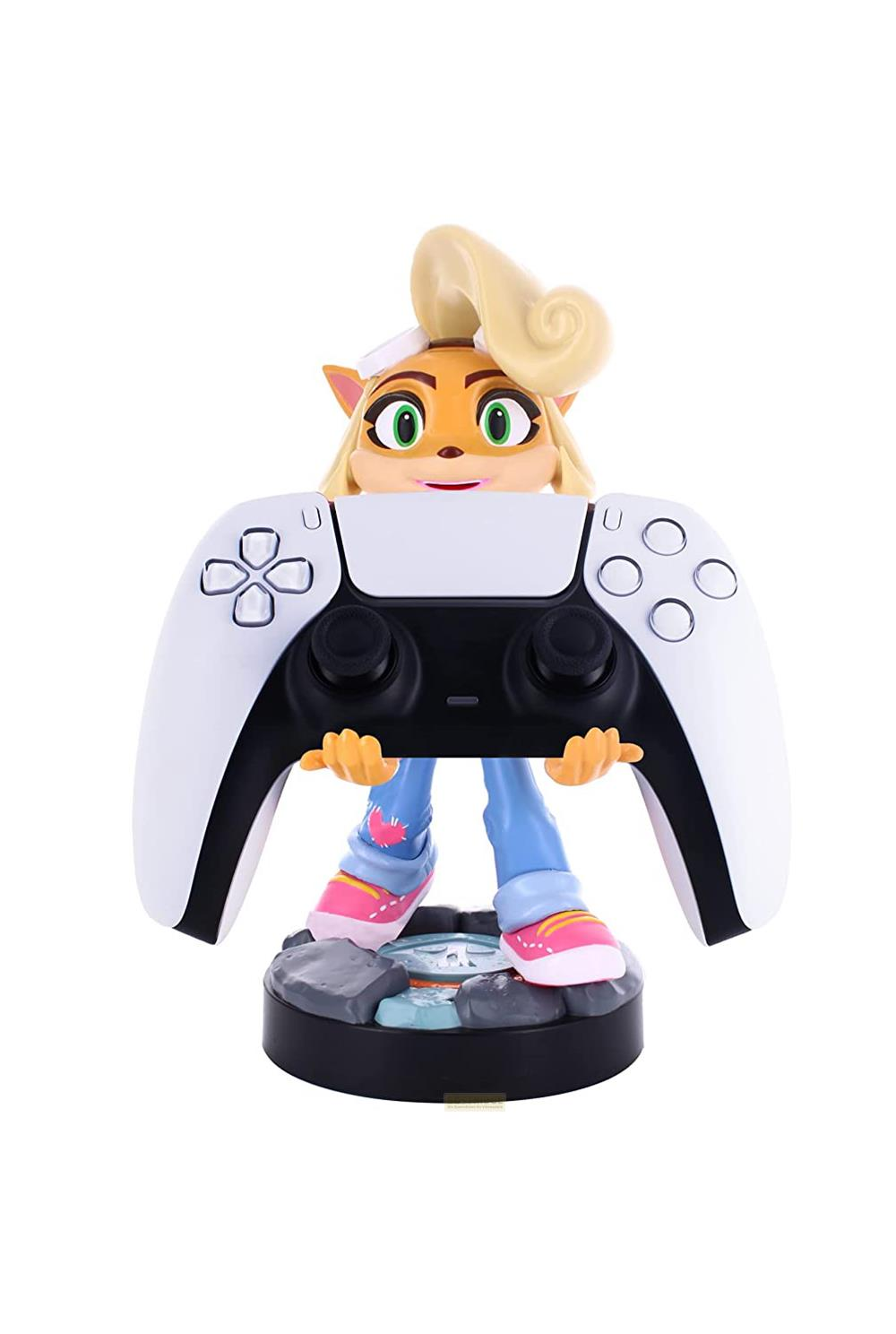 Un personaggio dei cartoni animati, Coco Bandicoot, tiene un controller PlayStation 5 bianco su sfondo bianco.