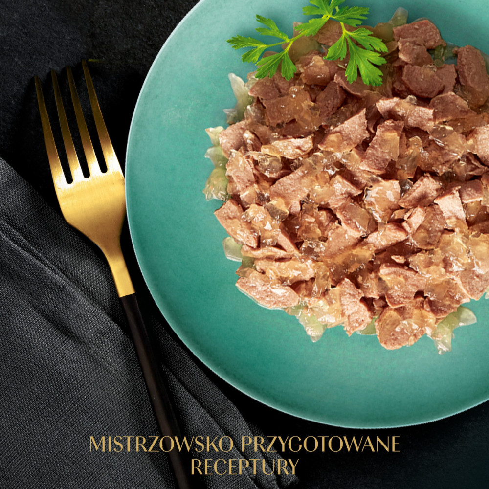 Kawałki mięsa w galarecie na turkusowym talerzu ze złotym widelcem.