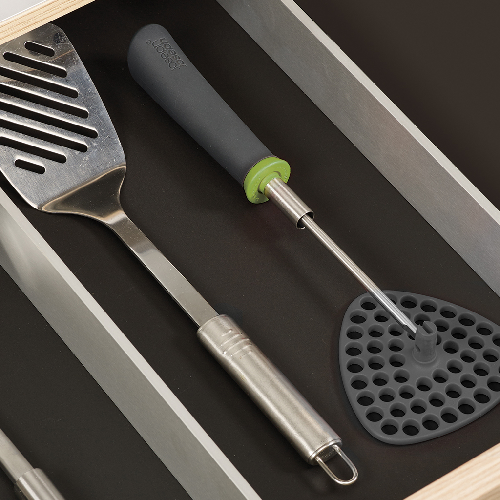 Çekmecede mutfak gereçleri: geniş bir spatula ve patates ezici.