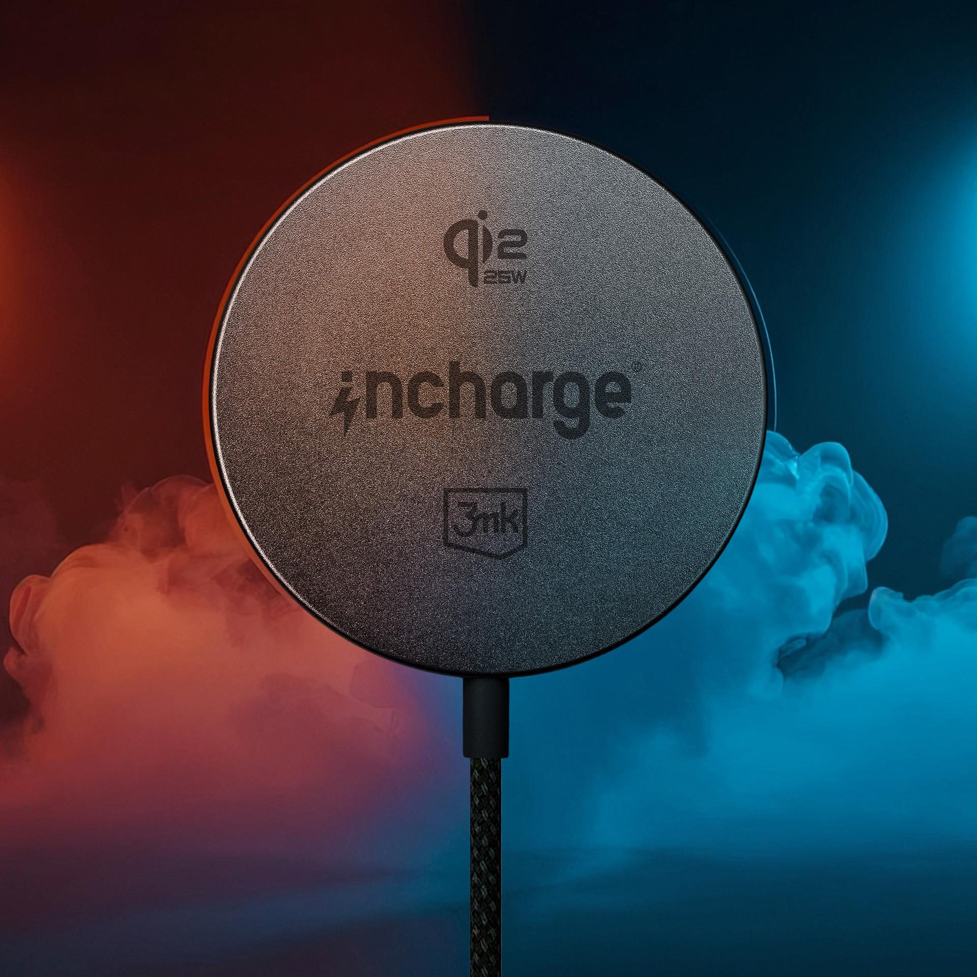 Okrągła czarna ładowarka z kablem, otoczona czerwonym i niebieskim dymem.