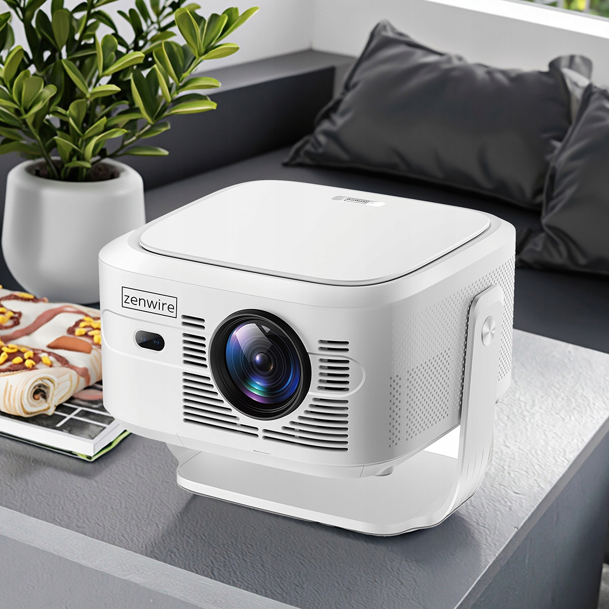 Biały projektor Zenwire stoi na stole obok rośliny doniczkowej.