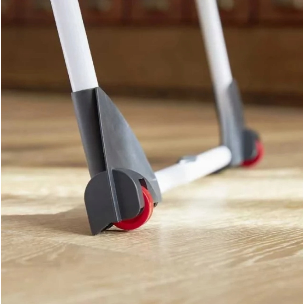 Zbliżenie na dwie białe nogi z szarymi wspornikami i czerwonymi kółkami na drewnianej podłodze.