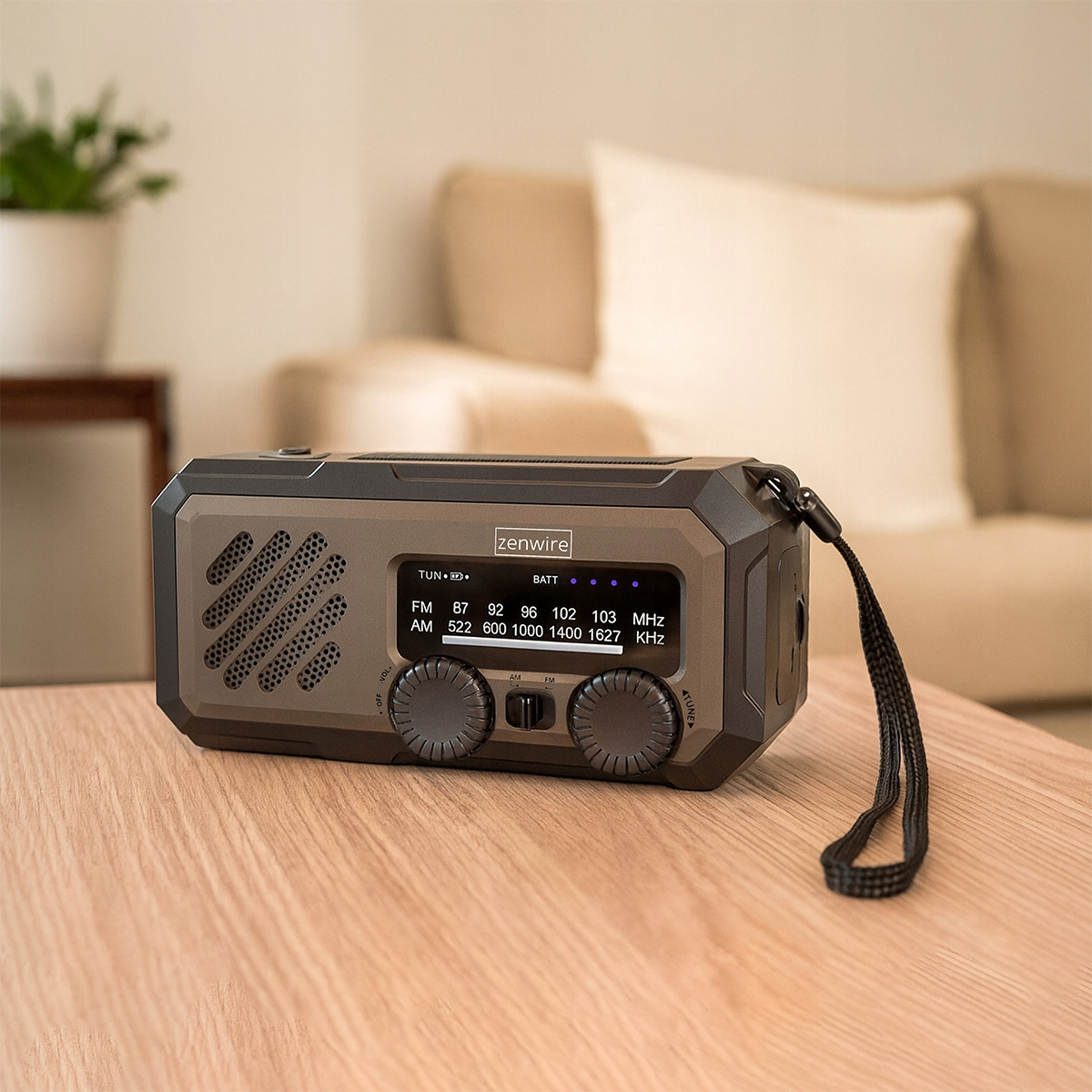Przenośne radio Zenwire na drewnianym stole z sofami w tle.