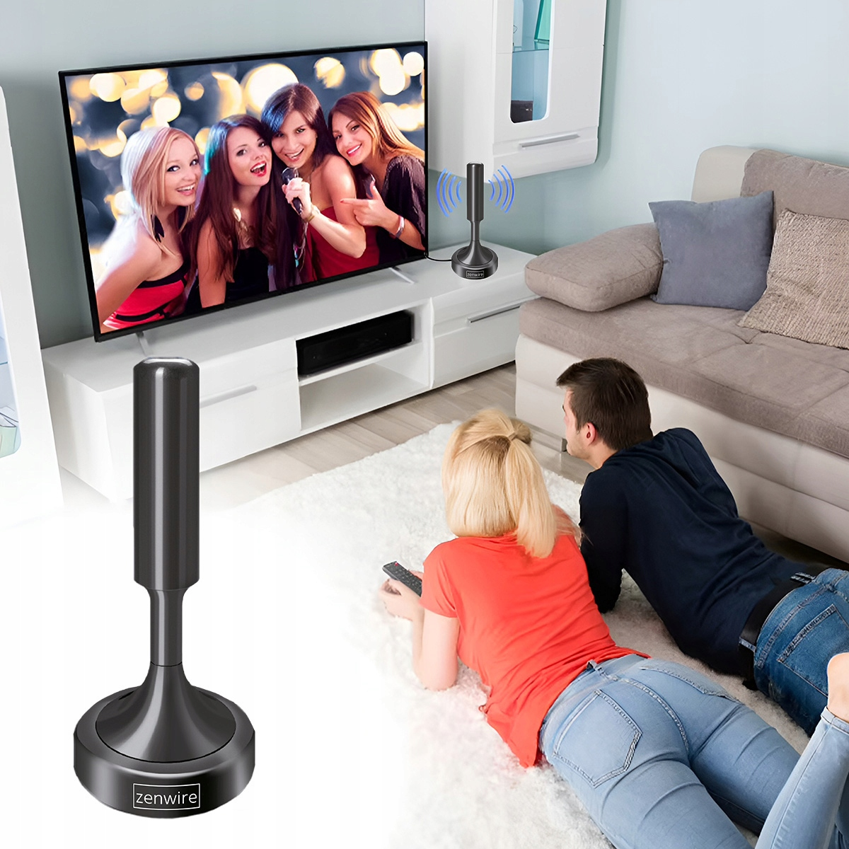 Para leży na dywanie, oglądając telewizję. Widoczna ikona anteny.