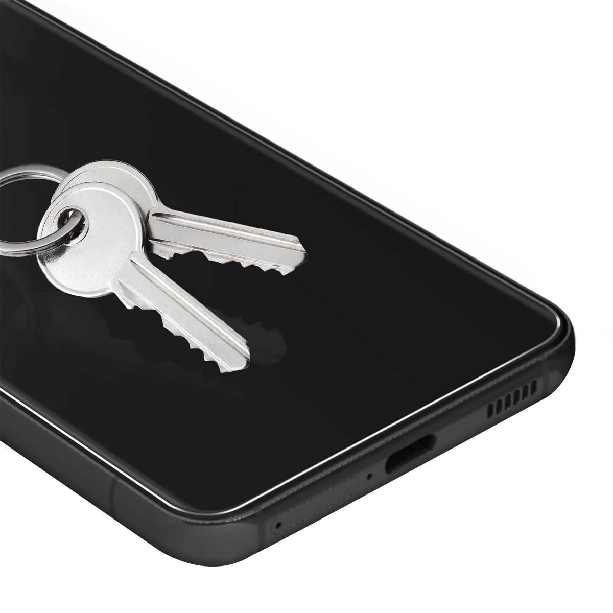 Deux clés argentées reposent sur un smartphone noir.