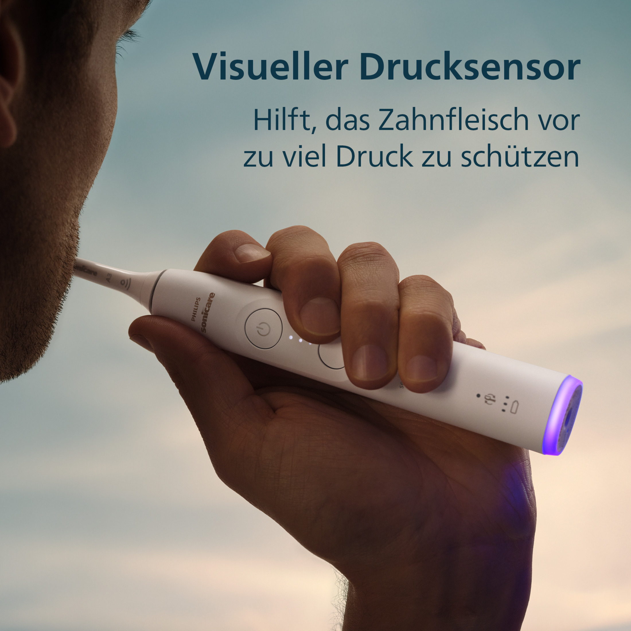 Mann hält weiße Philips Sonicare Zahnbürste mit blauem Licht