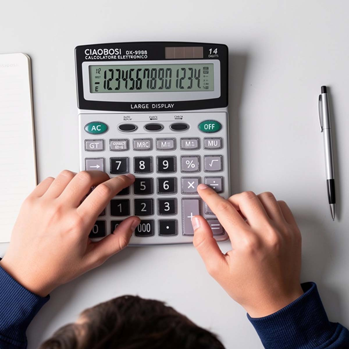 Des mains utilisent une calculatrice à grand écran. Un stylo est à proximité.