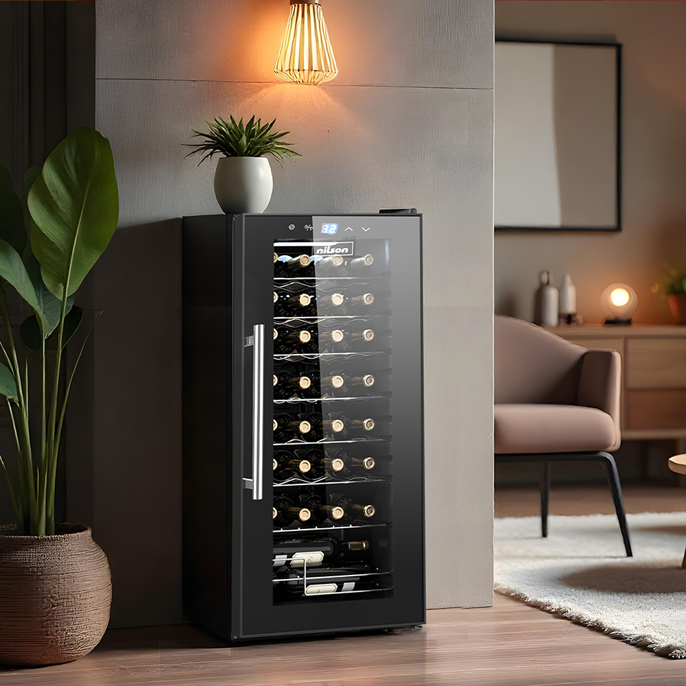 Una vinoteca negra con puerta de cristal, llena de botellas de vino, junto a una planta grande.