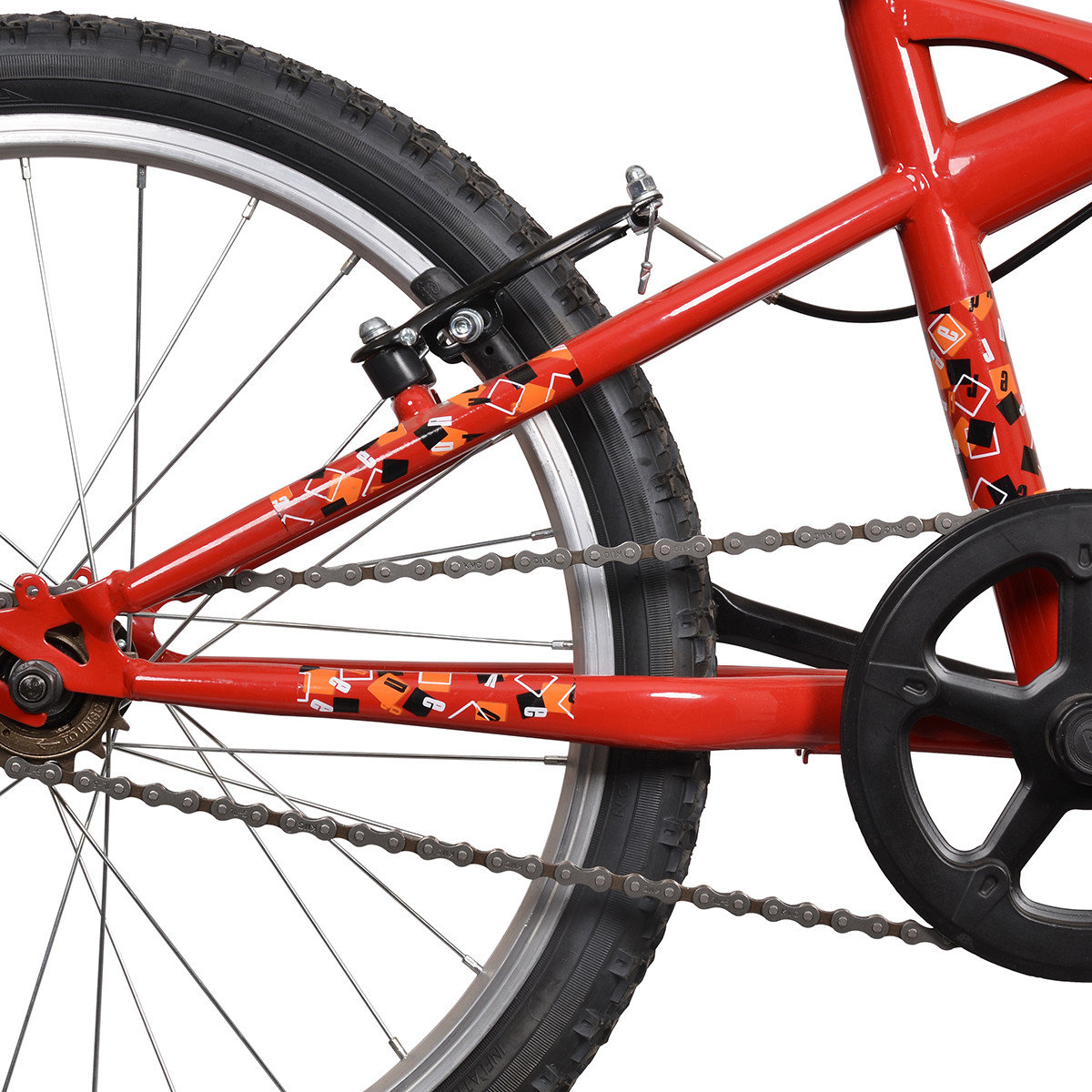 Czerwony rower z zębatką, łańcuchem i kołem szprychowym. Ozdobiony pomarańczowymi i czarnymi kwadratami.