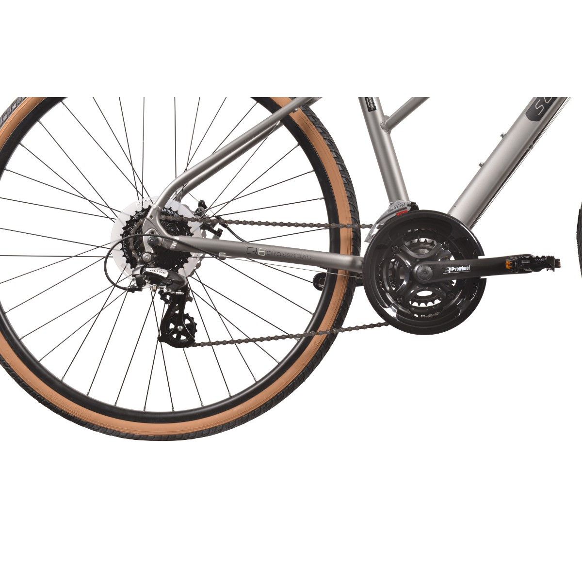 Zbliżenie srebrnej ramy roweru z łańcuchem, kasetą i kołem z brązową oponą.