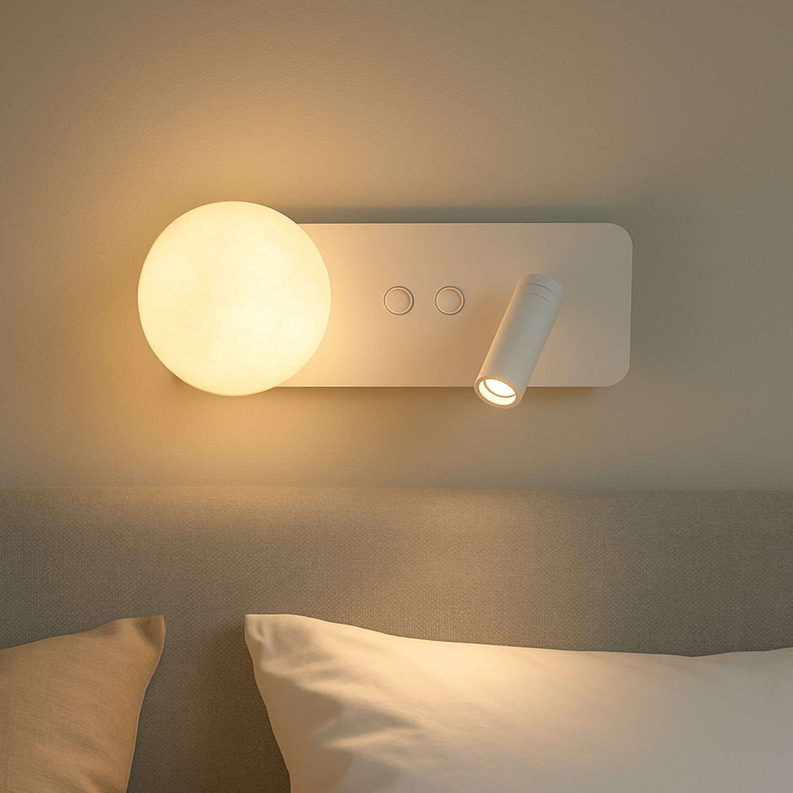 Una luz de pared blanca con esfera y foco sobre una cama con cojines.