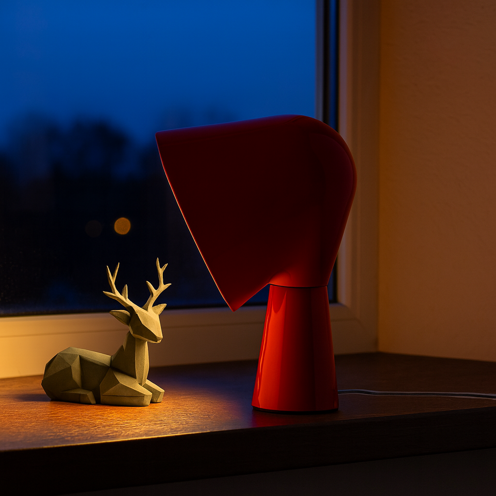 Una decoración de ciervo gris y una lámpara roja en un alféizar.