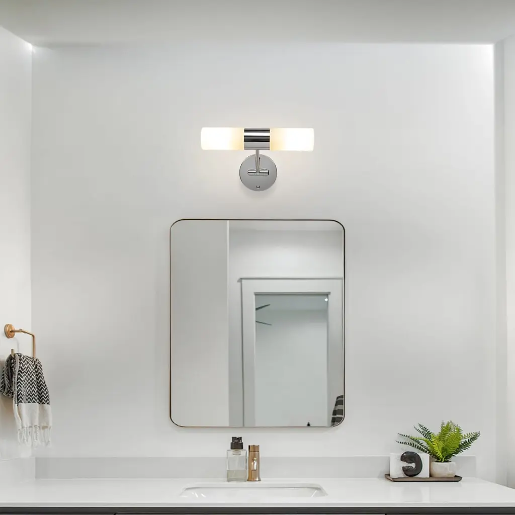 Baño moderno con espejo, lámpara, toallero y planta.
