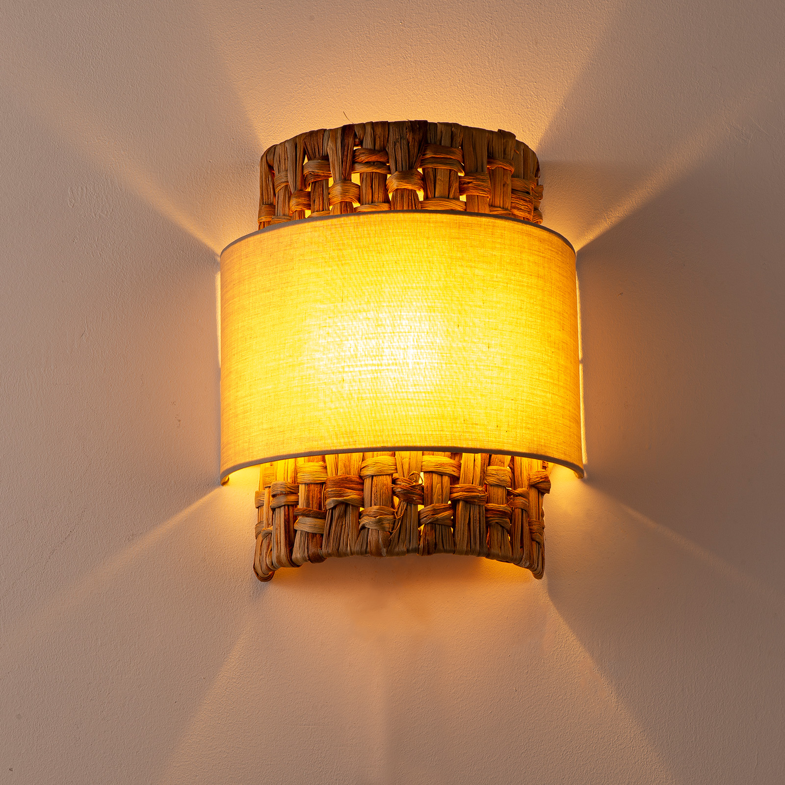 Aplique de pared con cesta de mimbre tejida y pantalla de tela amarilla.