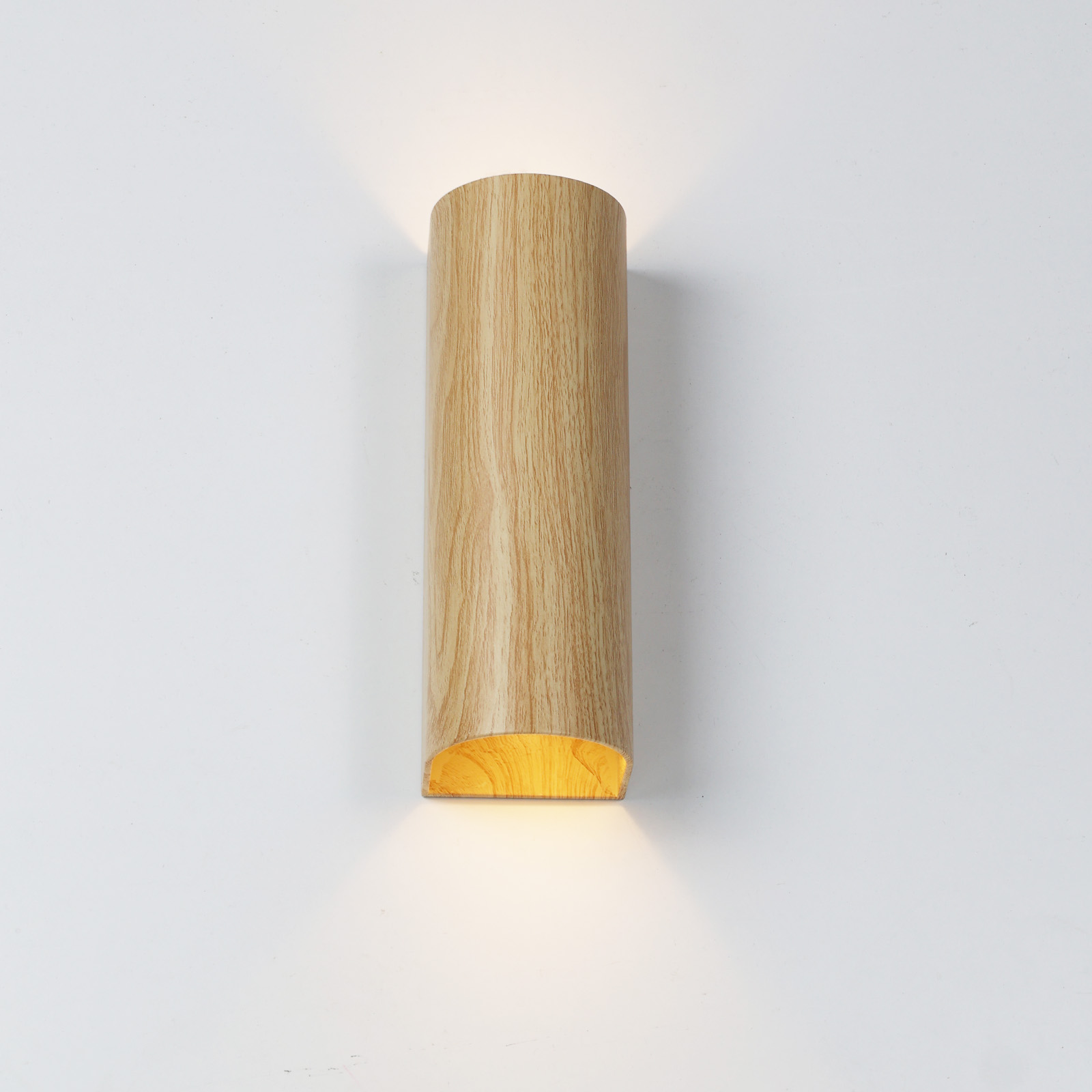 Una lámpara de pared cilíndrica de madera con luz hacia arriba y abajo.