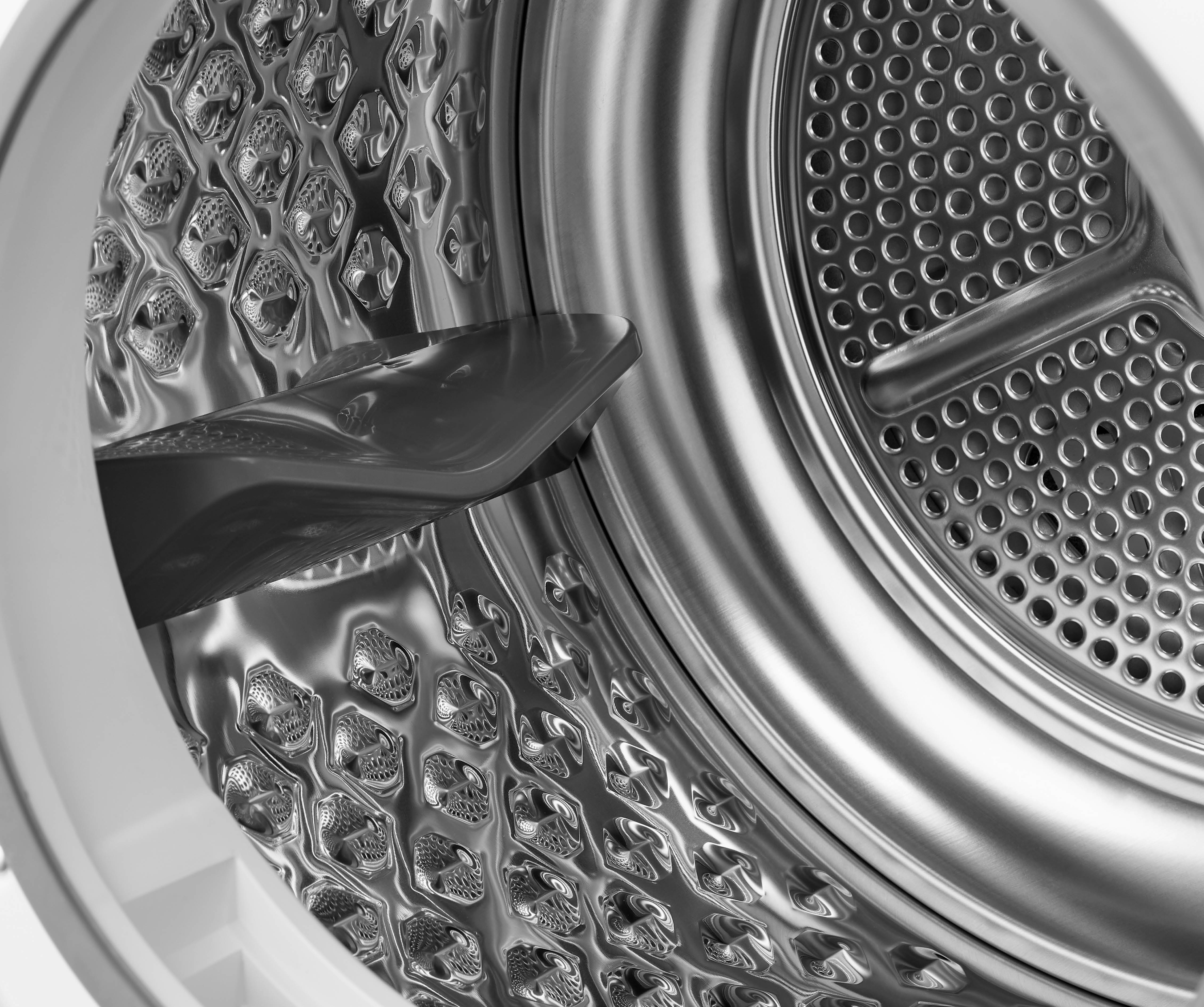Interior of a drum with a metallic surface and a pattern of holes.