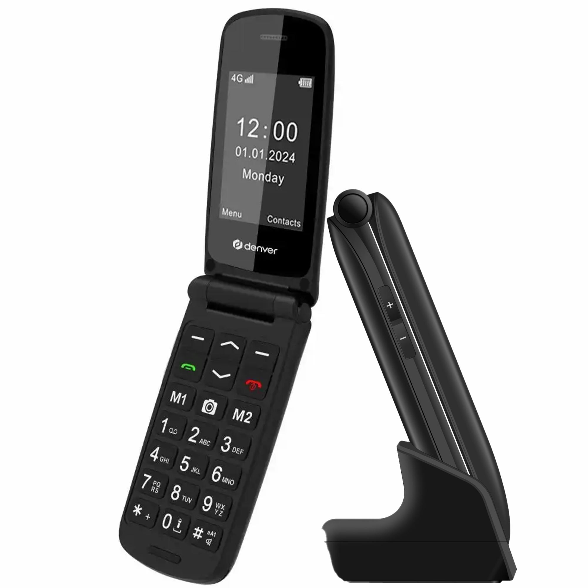 Un téléphone à clapet noir est ouvert, montrant l'écran avec l'heure et la date. Une station de charge est à côté.