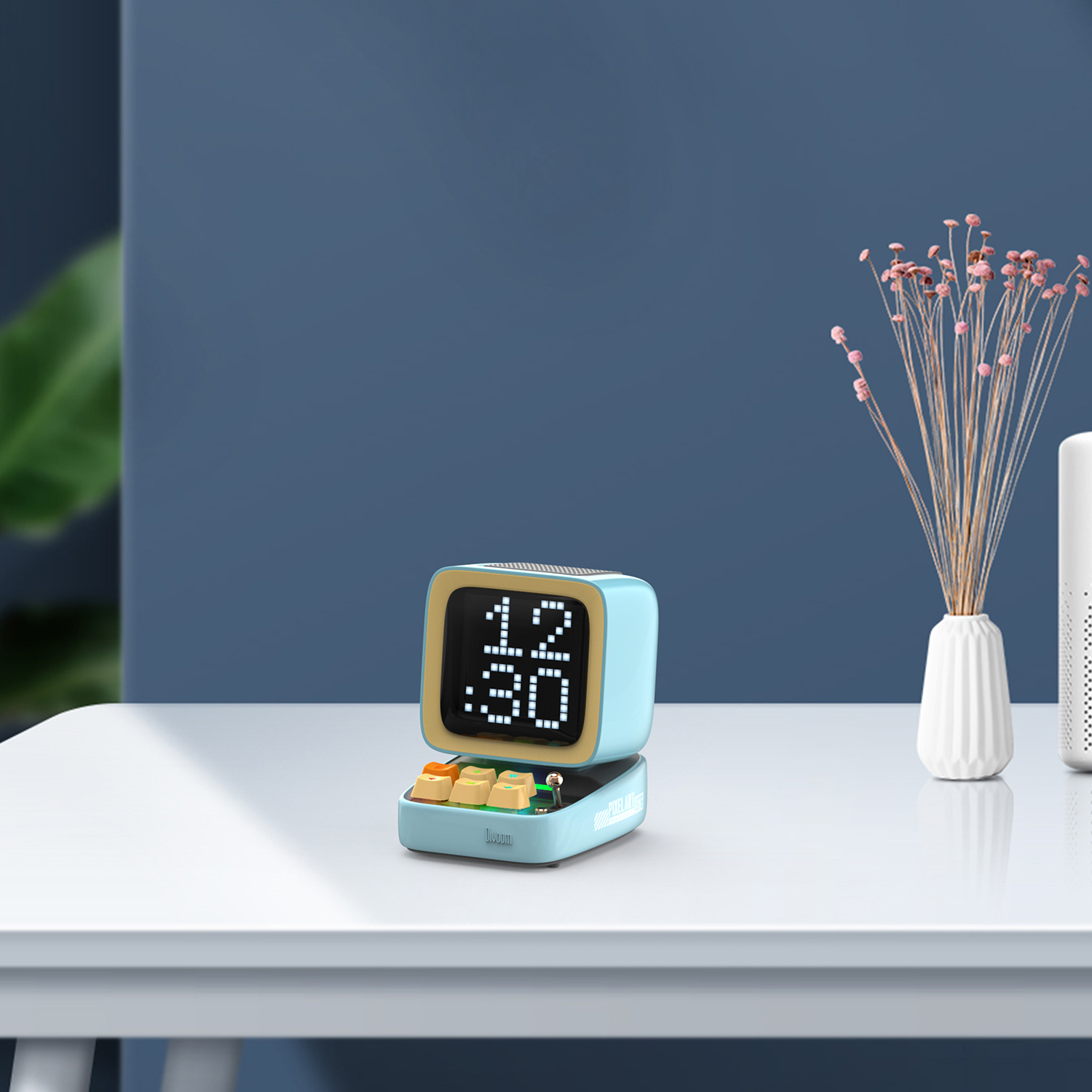 Jasnoniebieskie urządzenie pixel art z klawiaturą i godziną 12:30 na białym stole.