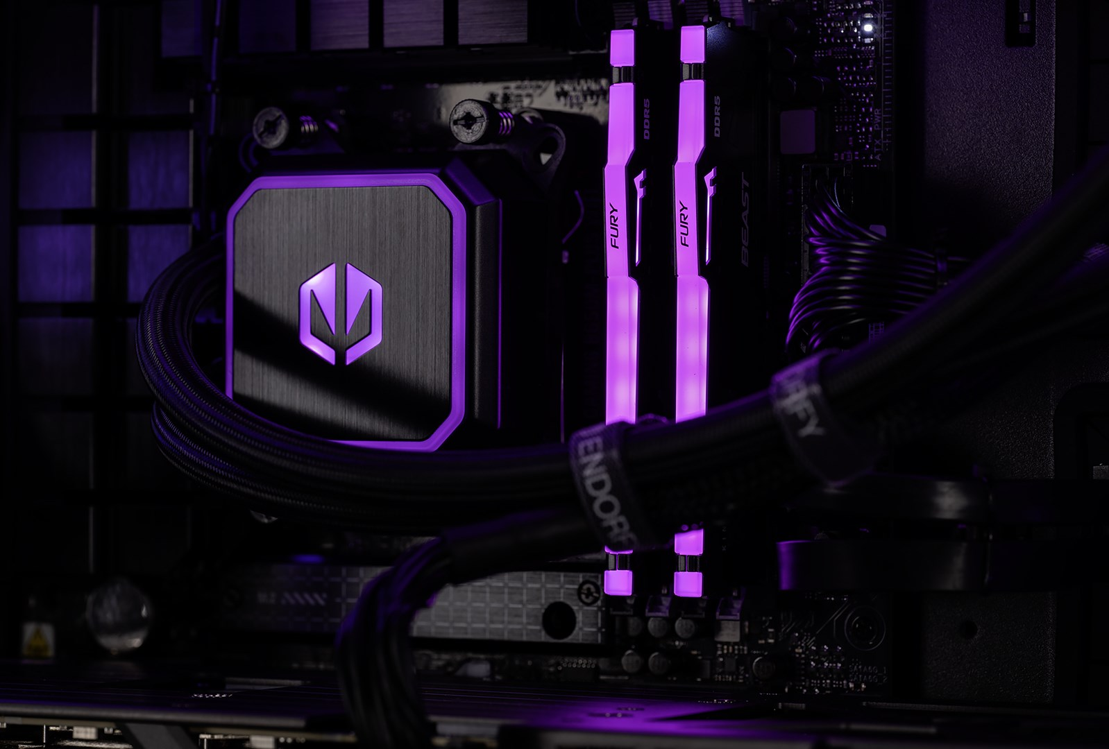 Un dissipatore CPU per computer con illuminazione viola, RAM e cavi.