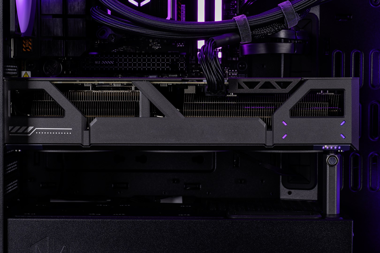 Primo piano di una scheda grafica interna di un computer con illuminazione a LED viola.