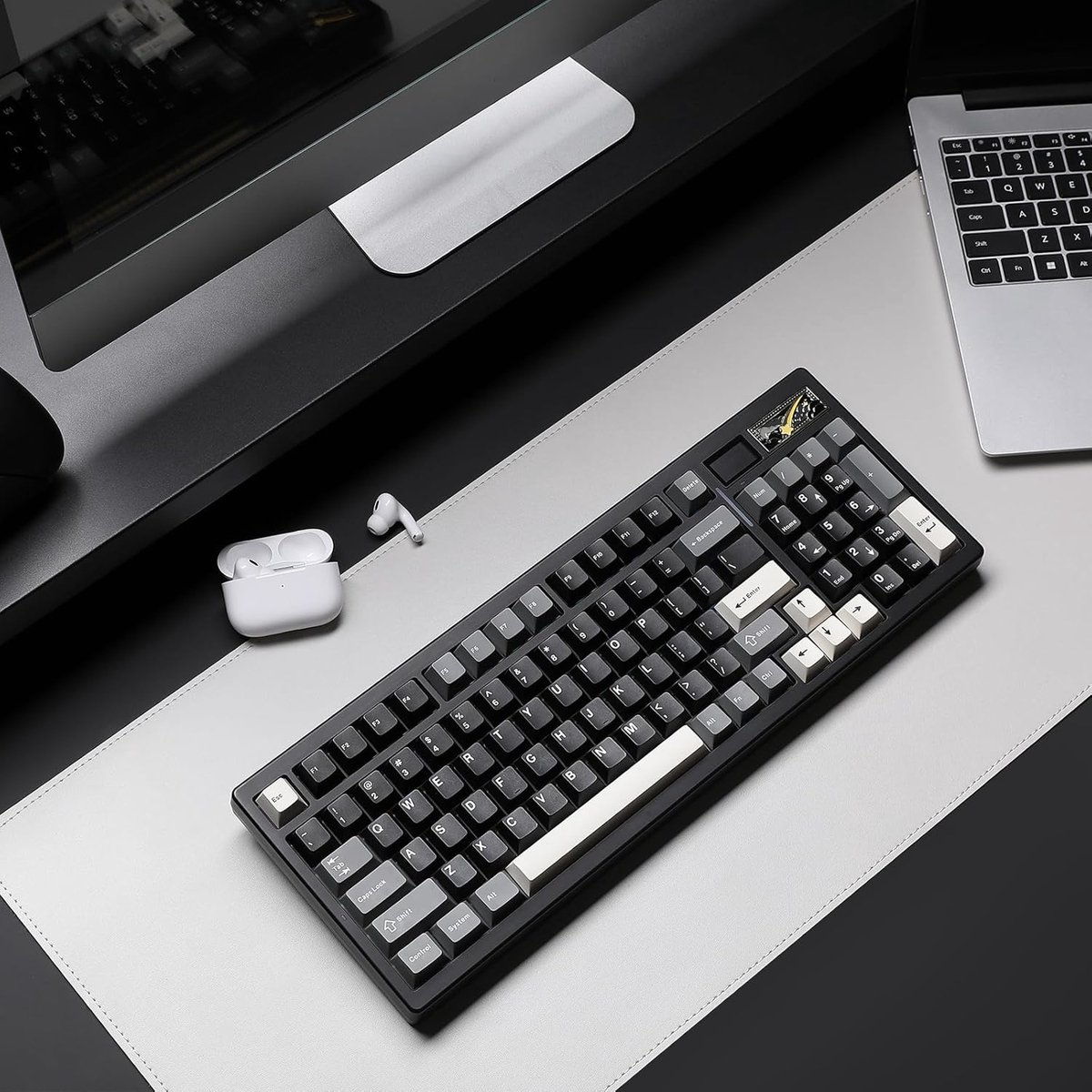 Clavier noir avec touches blanches et grises, à côté d'écouteurs blancs et d'un ordinateur portable.