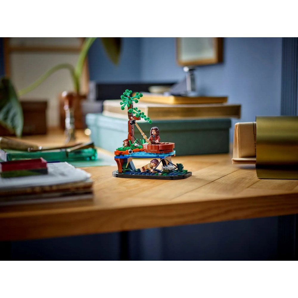 Zestaw Lego z dwiema postaciami, drzewem i studnią na drewnianym biurku.