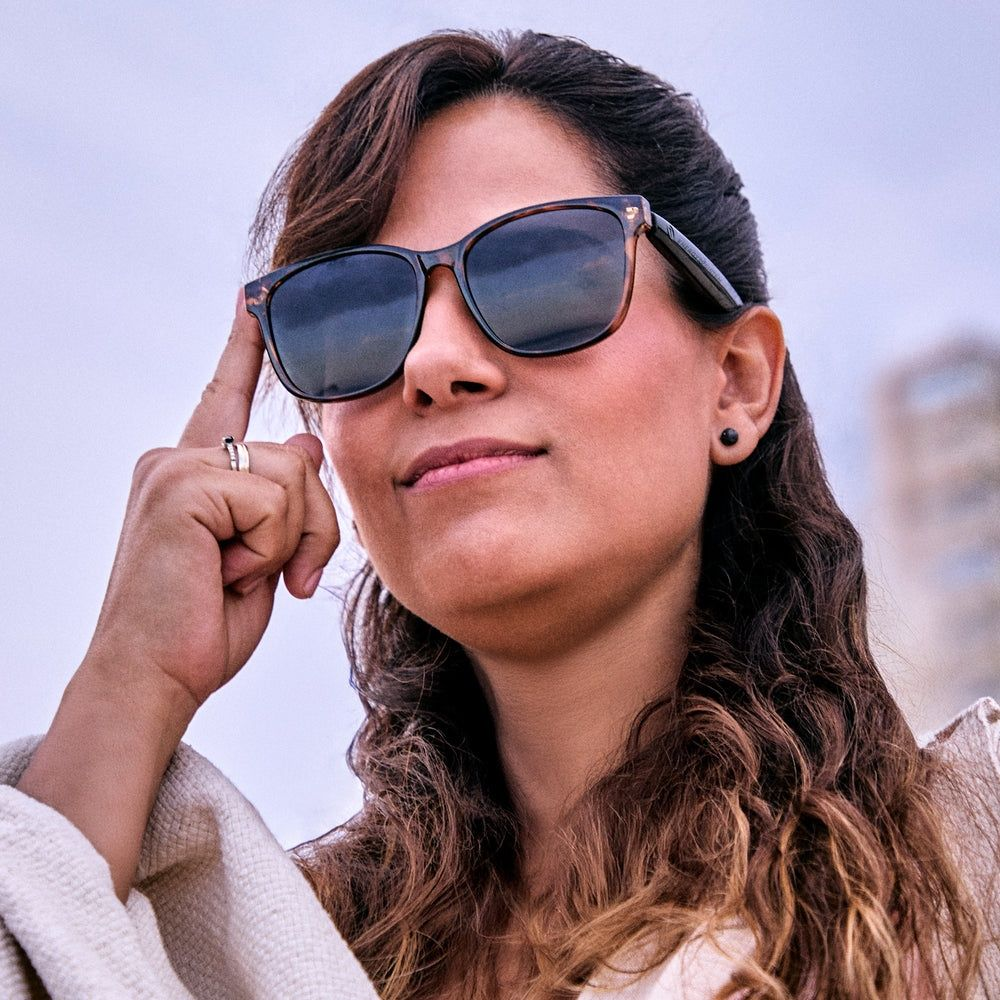 Eine Frau mit Sonnenbrille und Ohrstecker auf dem Kopf.