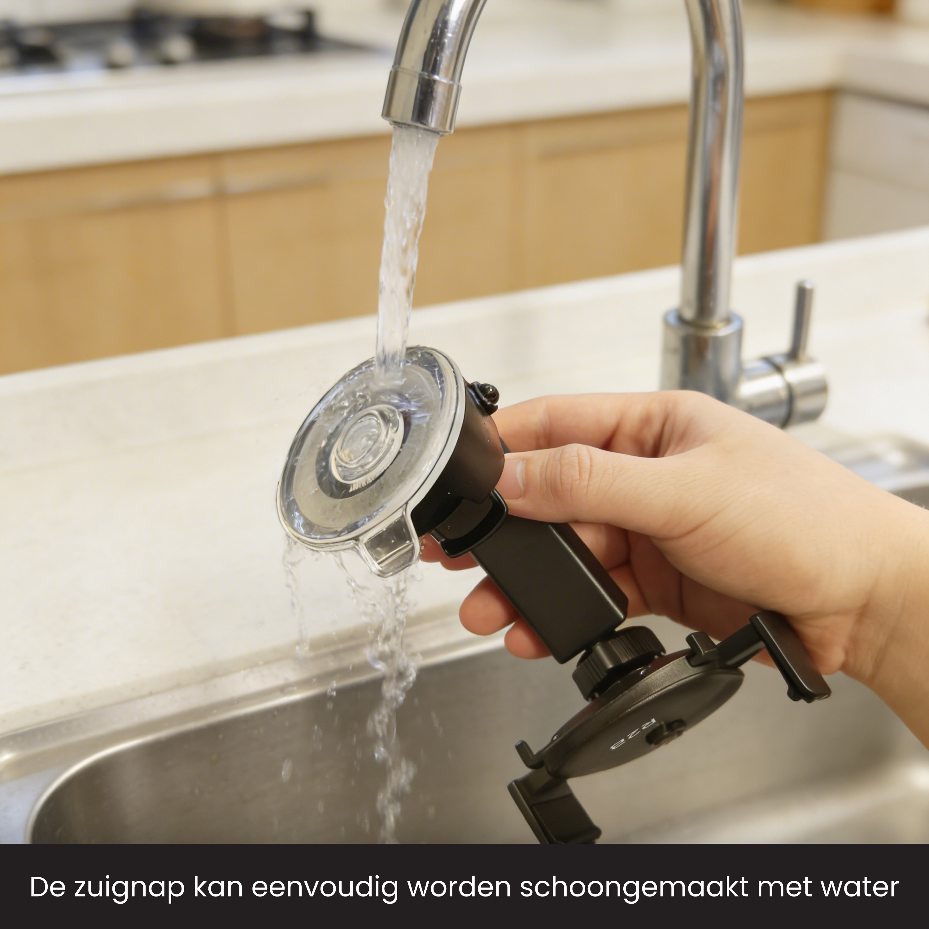 Eine Hand reinigt einen schwarzen Saugnapfhalter unter fließendem Wasser in einer Spüle.