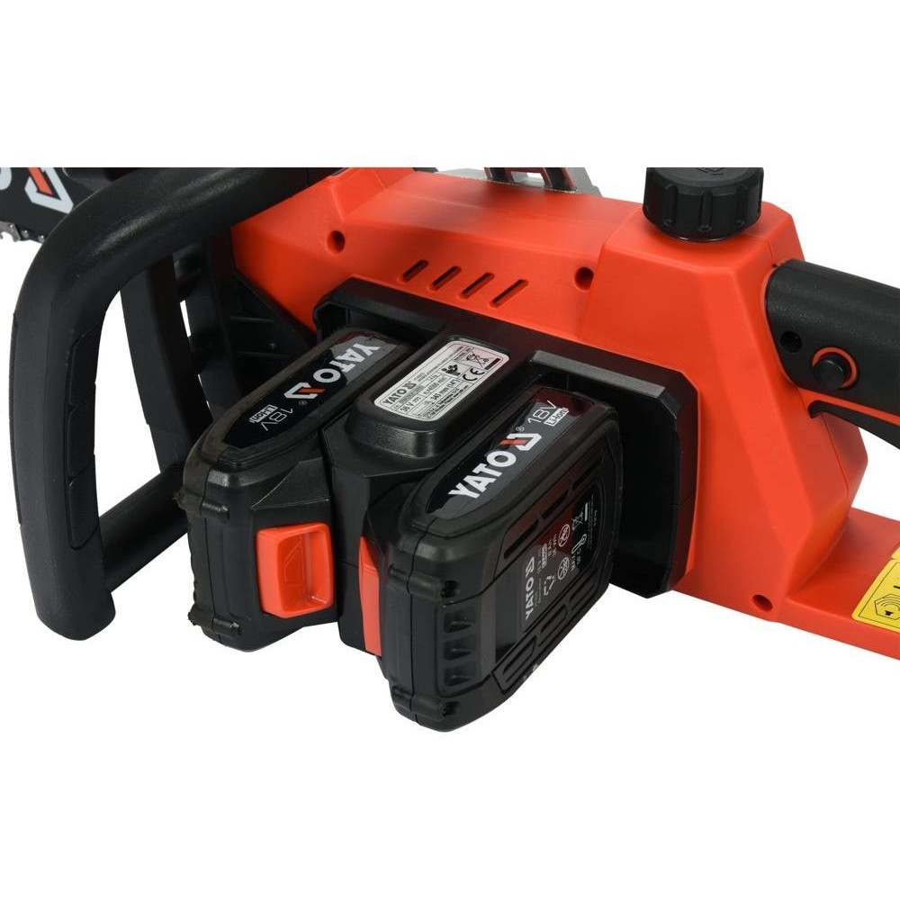 Una motosega arancione con due batterie YATO 18V inserite.
