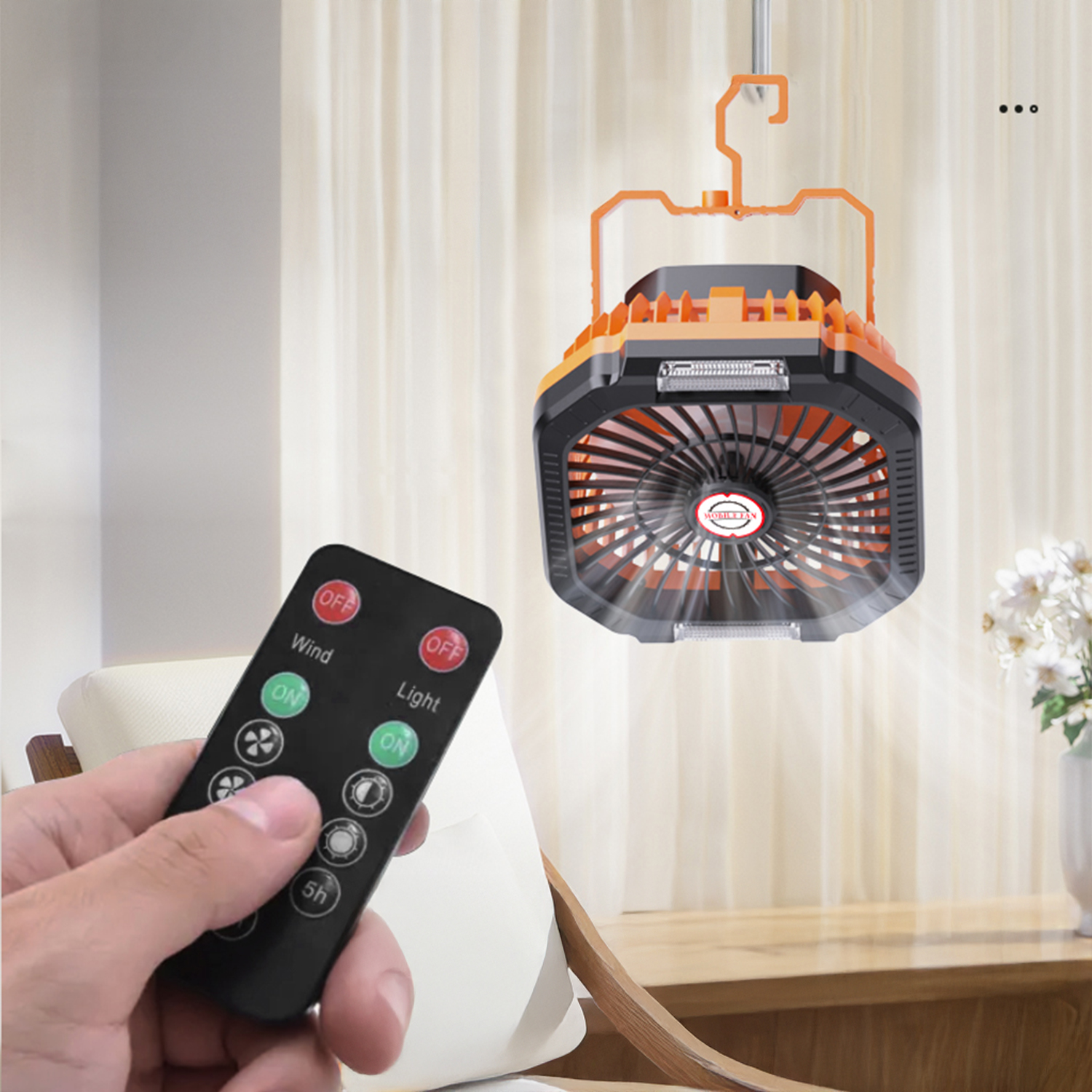 Un uomo tiene un telecomando. Un ventilatore arancione e nero con luce pende dal soffitto.
