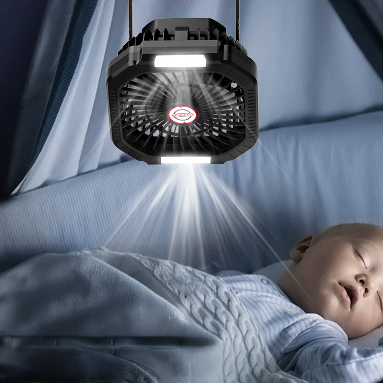Una ventola nera con luci pende sopra un bambino che dorme in un letto.