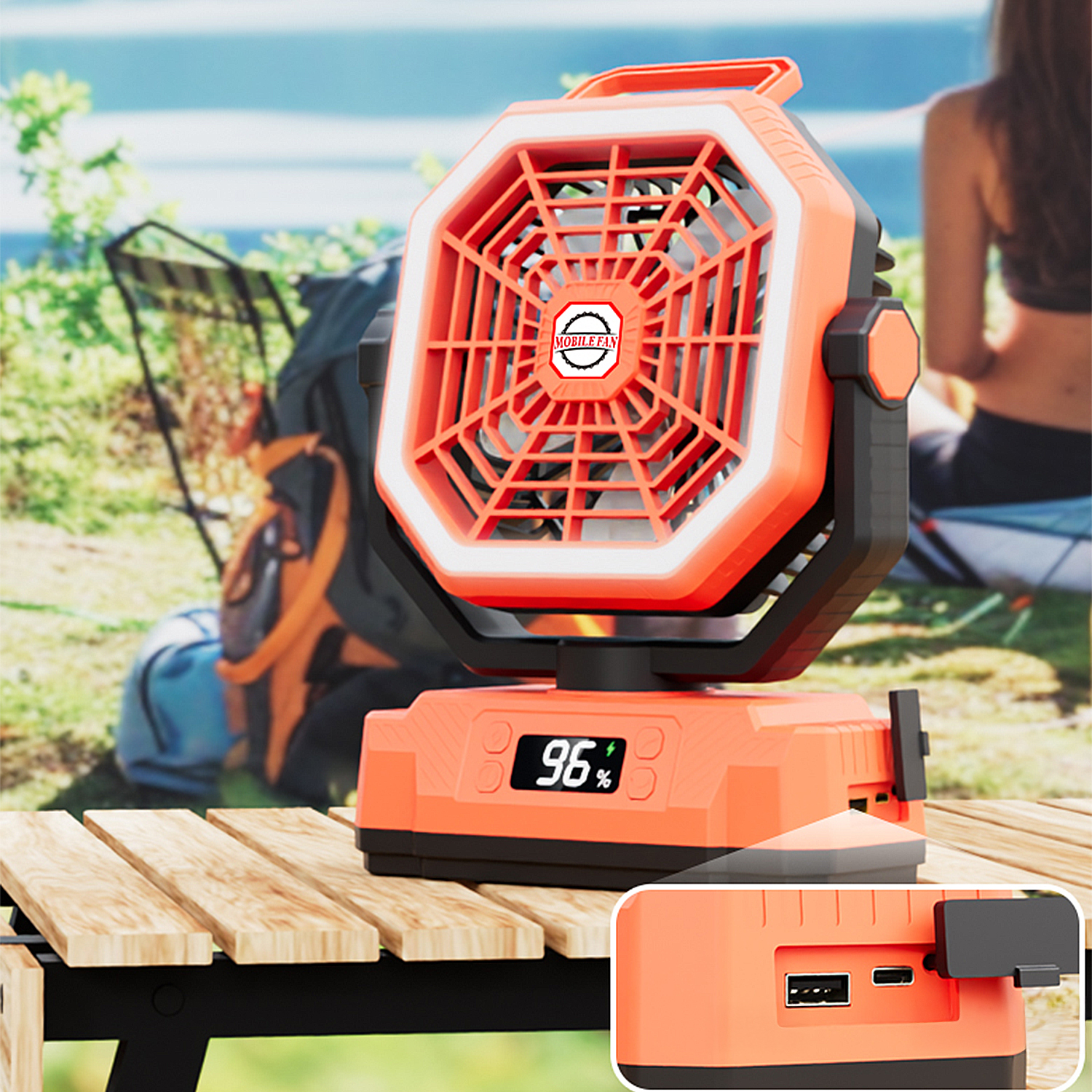 Ventilador portátil naranja con 96% de batería en mesa de madera.