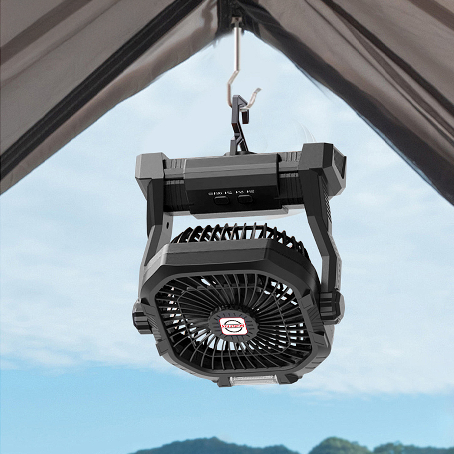 Ventilatore da campeggio nero con gancio appeso sotto una tenda. Cielo blu.