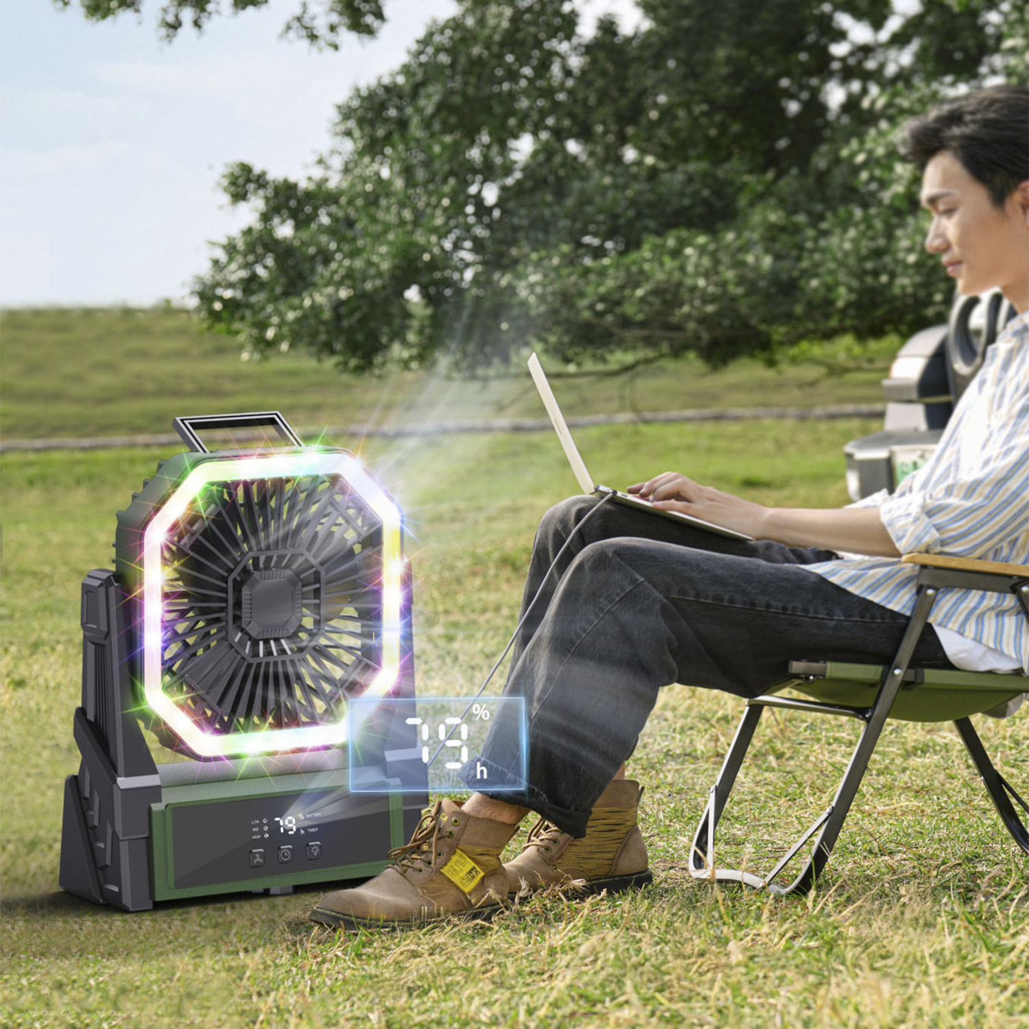 Un uomo usa un laptop all'aperto, con un ventilatore colorato e display digitale nelle vicinanze.