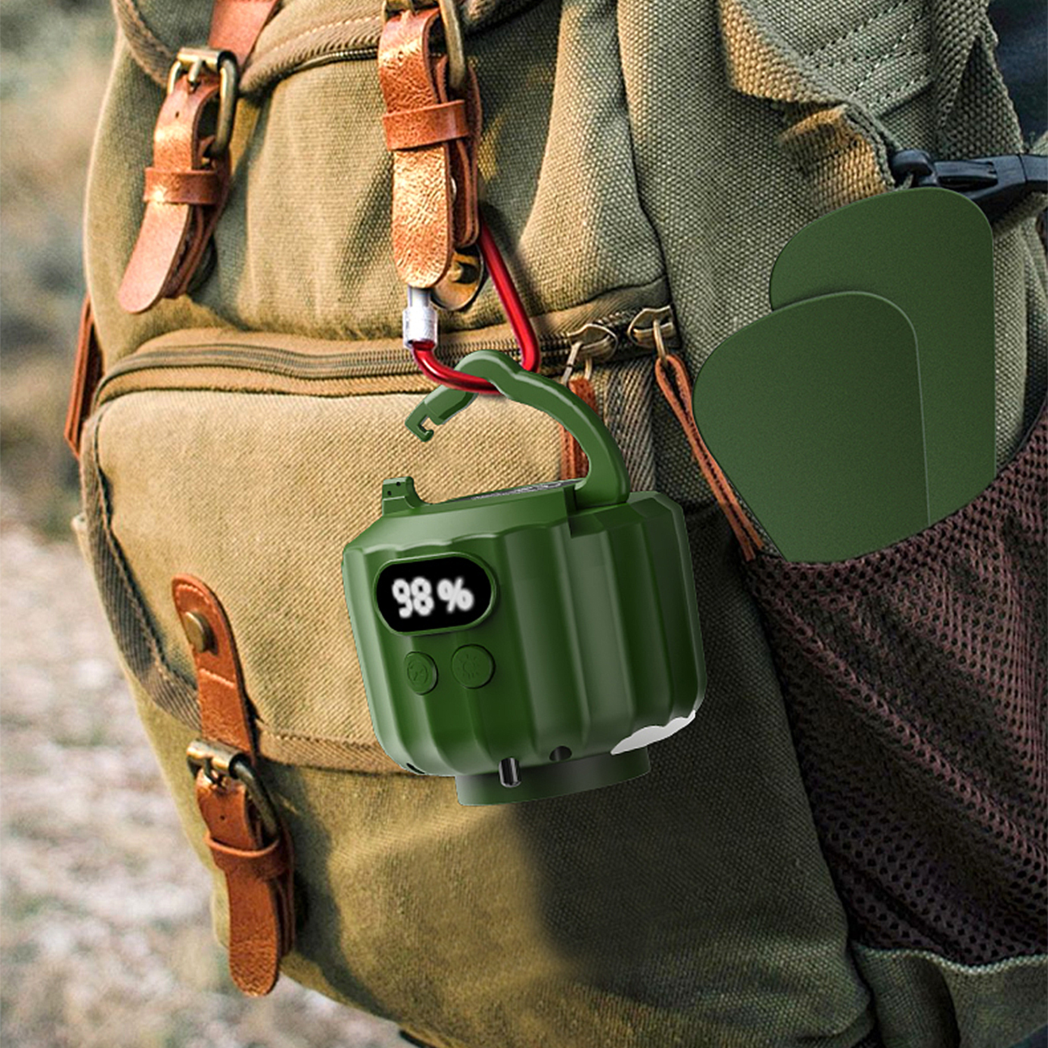 Un dispositivo verde con display 98% è appeso a uno zaino.