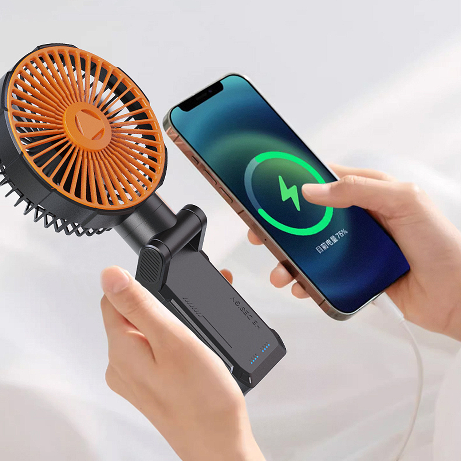 Ventilatore portatile e smartphone in carica.