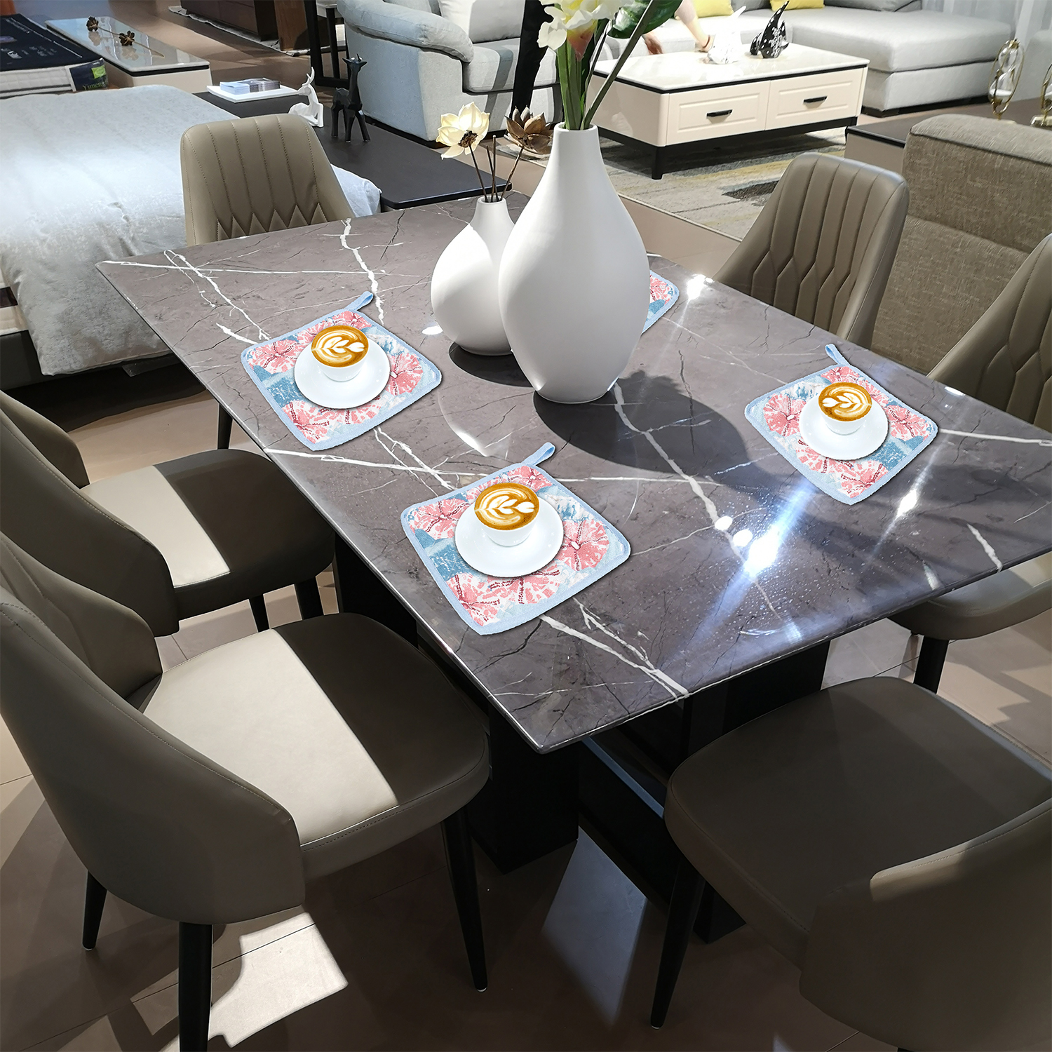 Un tavolo da pranzo con quattro tazze di caffè su sottobicchieri, vasi e sedie.