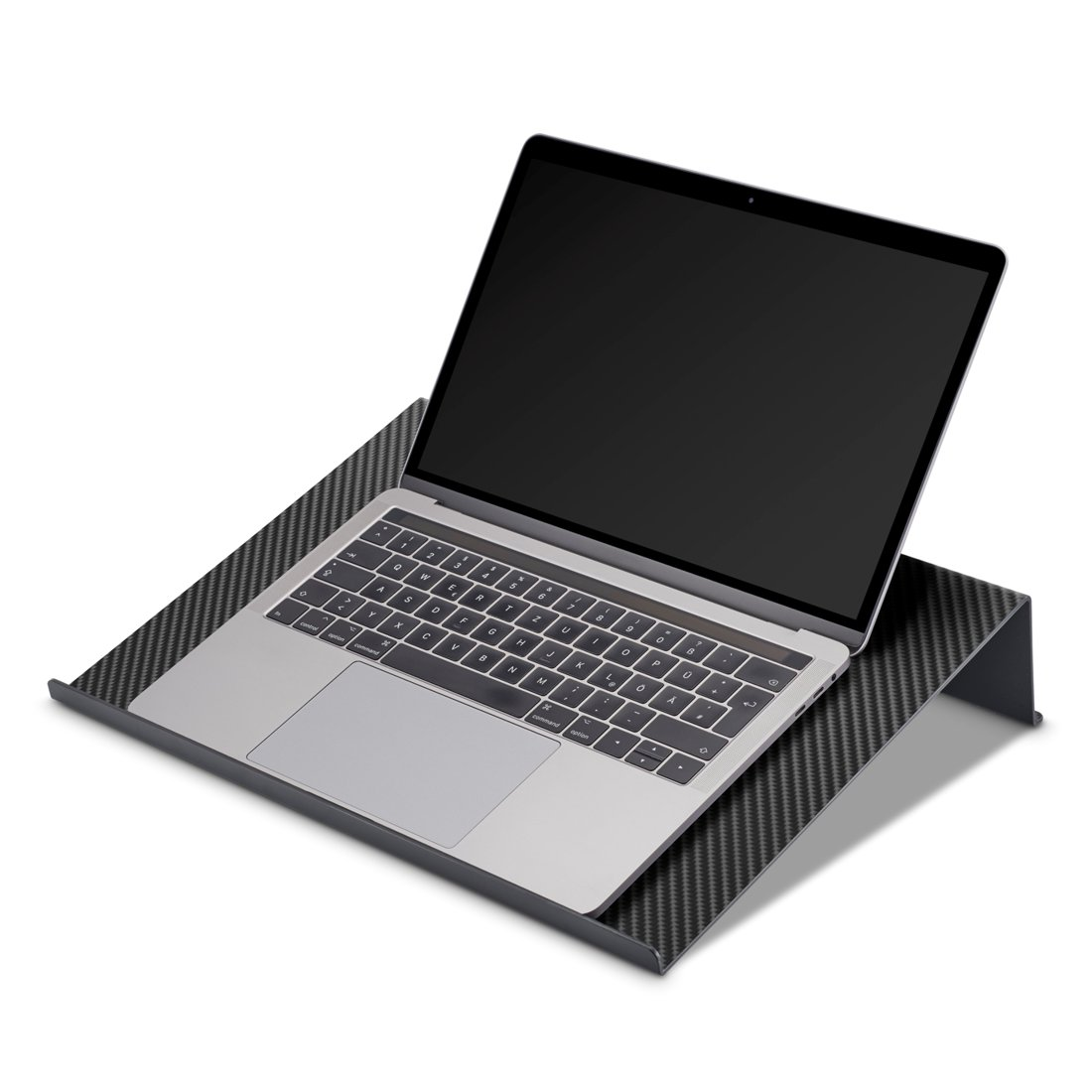 Un laptop argentato poggia su un supporto nero con motivo in fibra di carbonio.