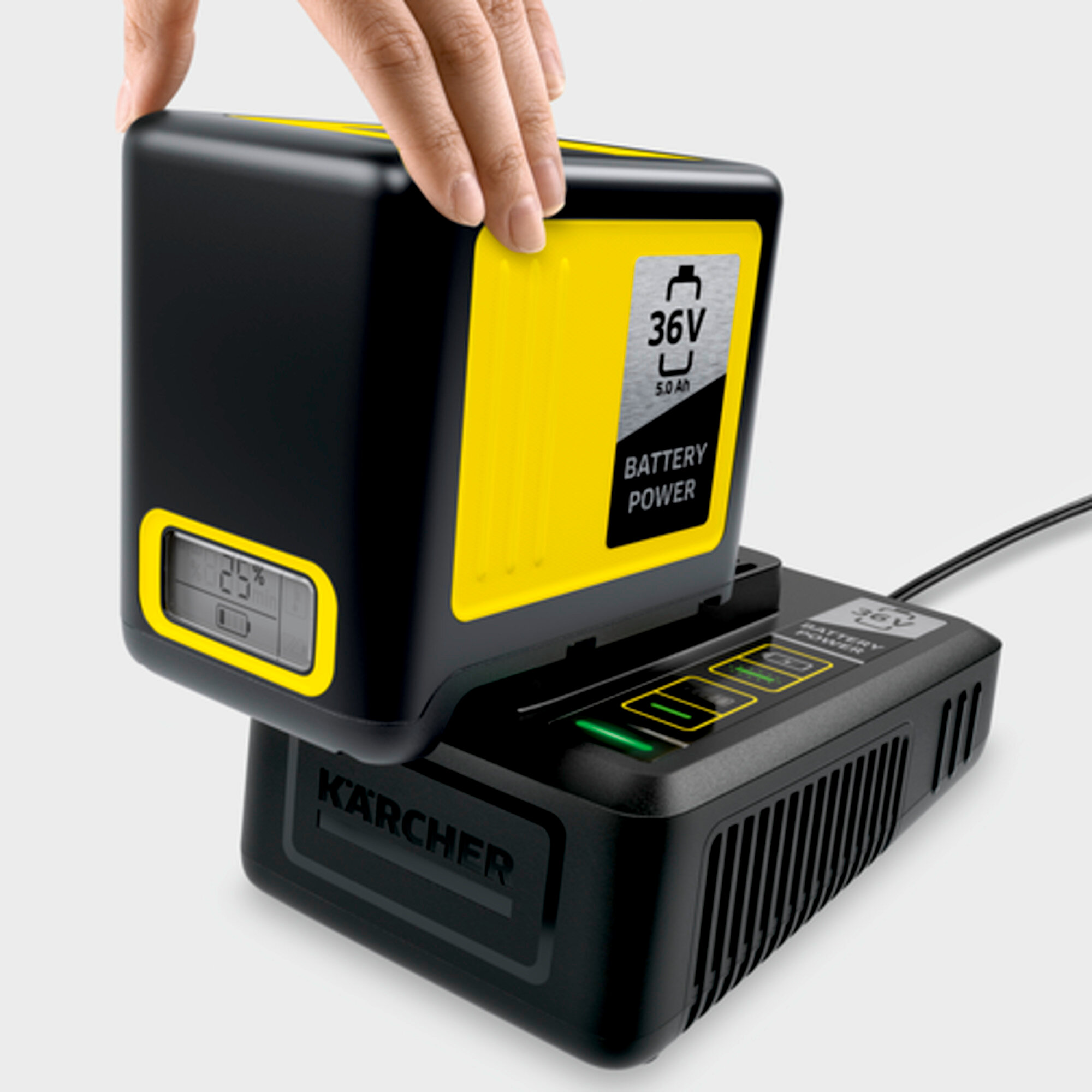 Una mano posiziona una batteria nera con accenti gialli su un caricabatterie.