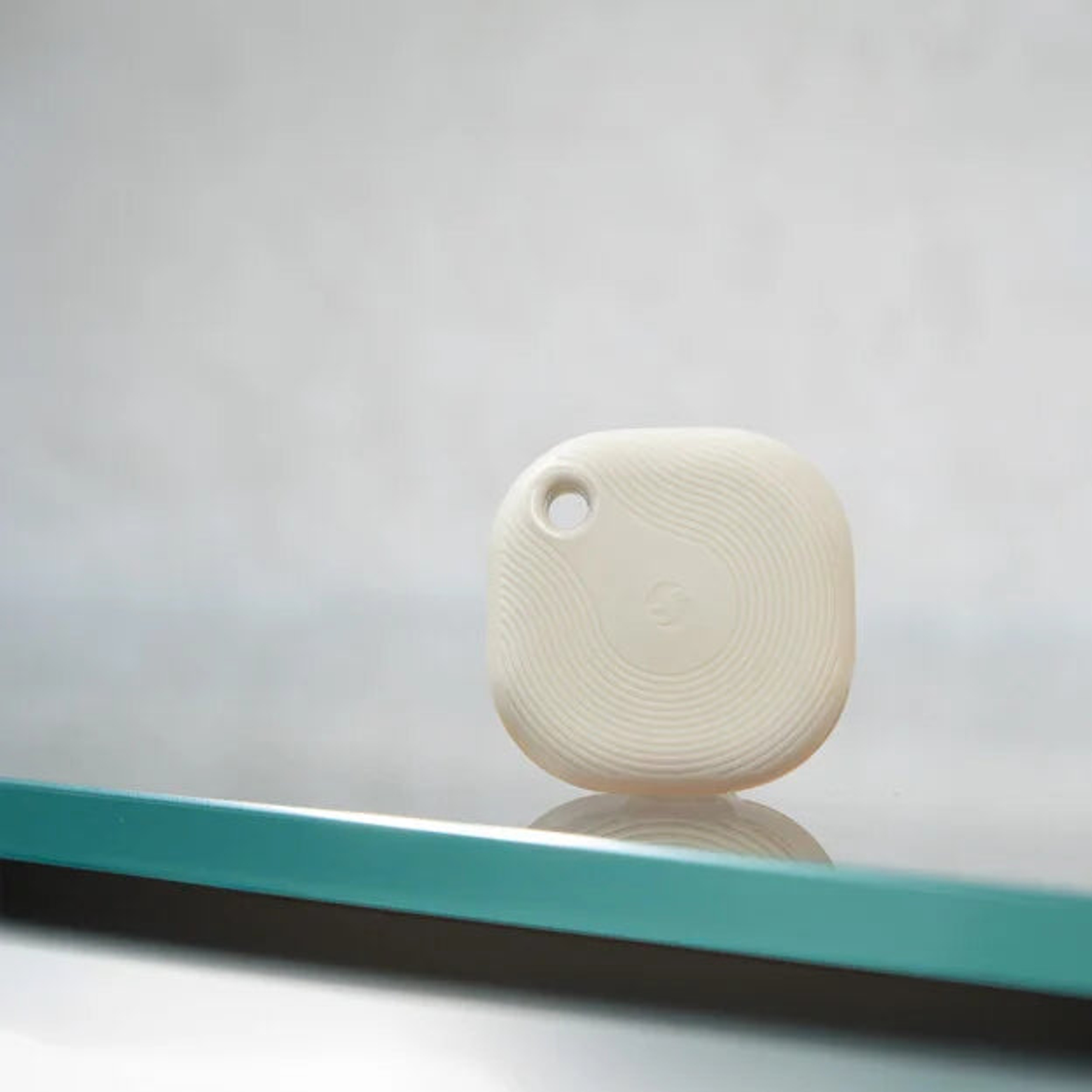 Un localizzatore color crema con linee circolari su una superficie blu.