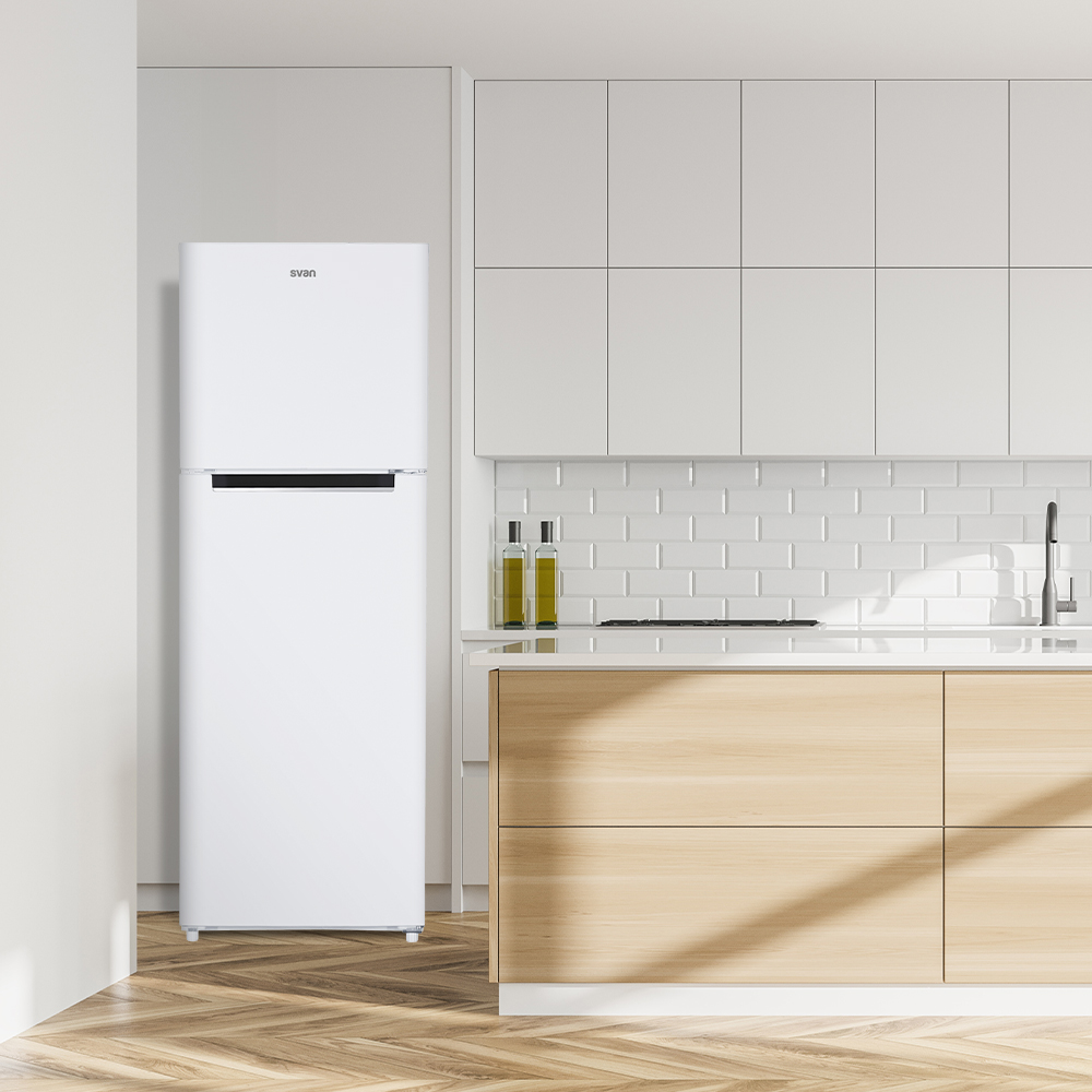 Un refrigerador blanco junto a una encimera de cocina con gabinetes de madera.