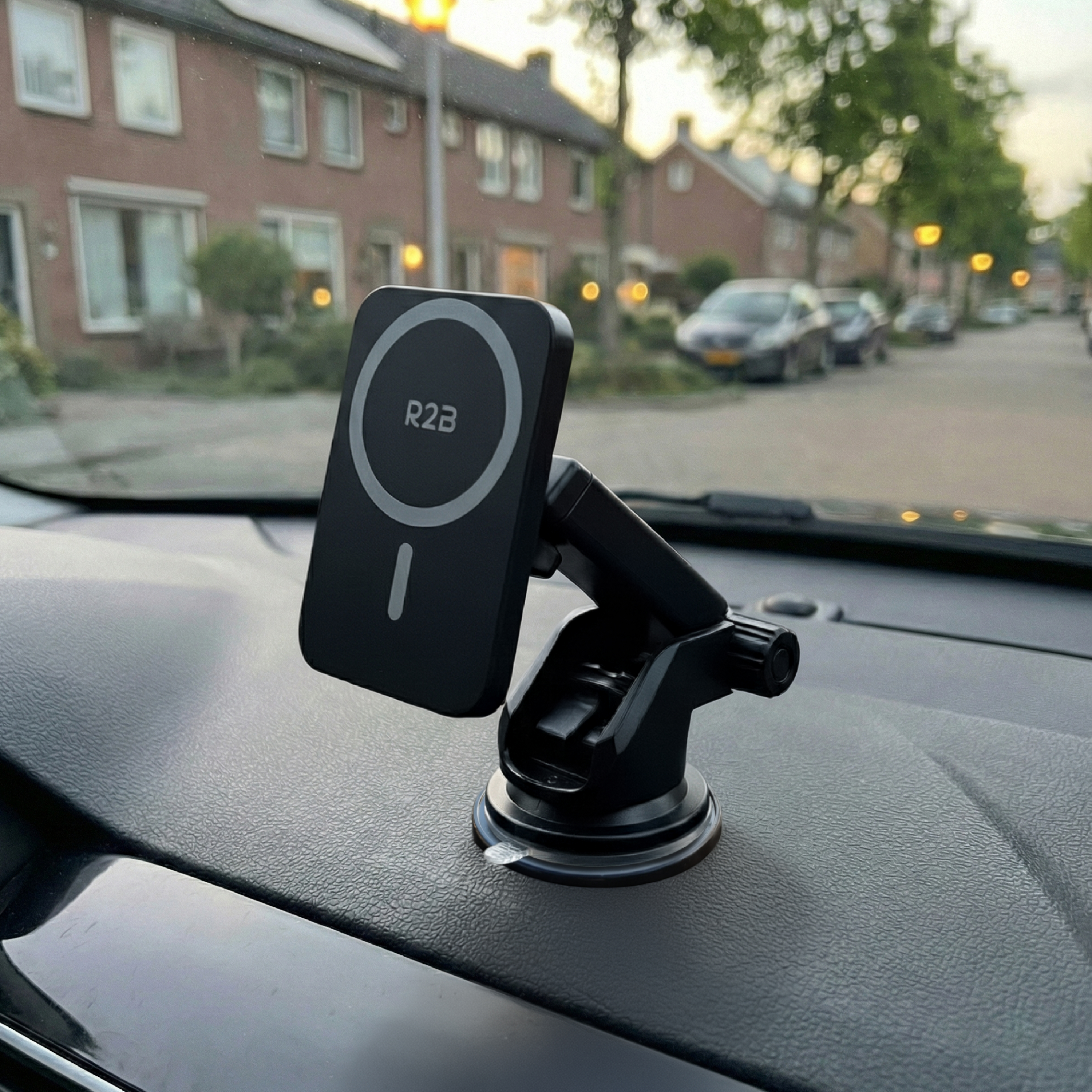 Een zwarte telefoonhouder met R2B-logo op een auto-dashboard.