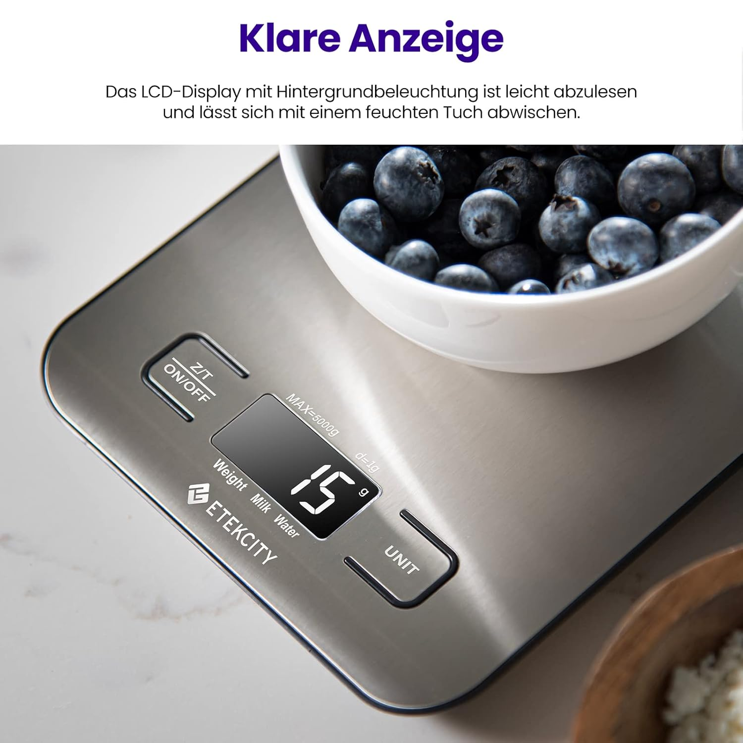 Digitale Küchenwaage mit Schüssel voller Blaubeeren und LCD-Anzeige.