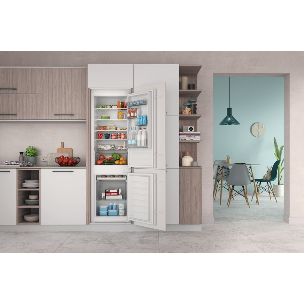 Ein offener Kühlschrank in einer modernen Küche mit Lebensmitteln und daneben ein Essbereich.