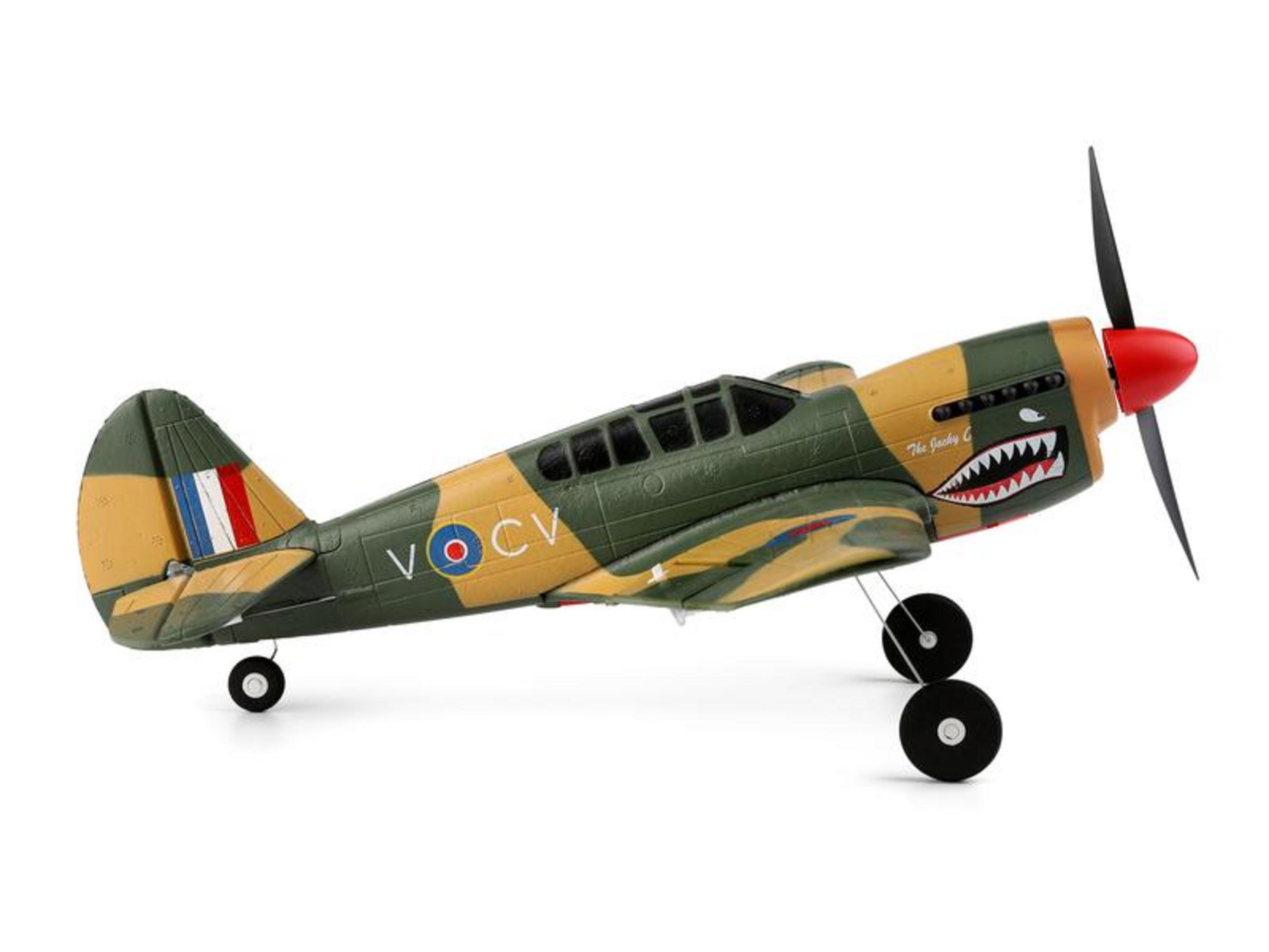 Un avion modèle vert et beige avec nez de requin et hélice rouge.