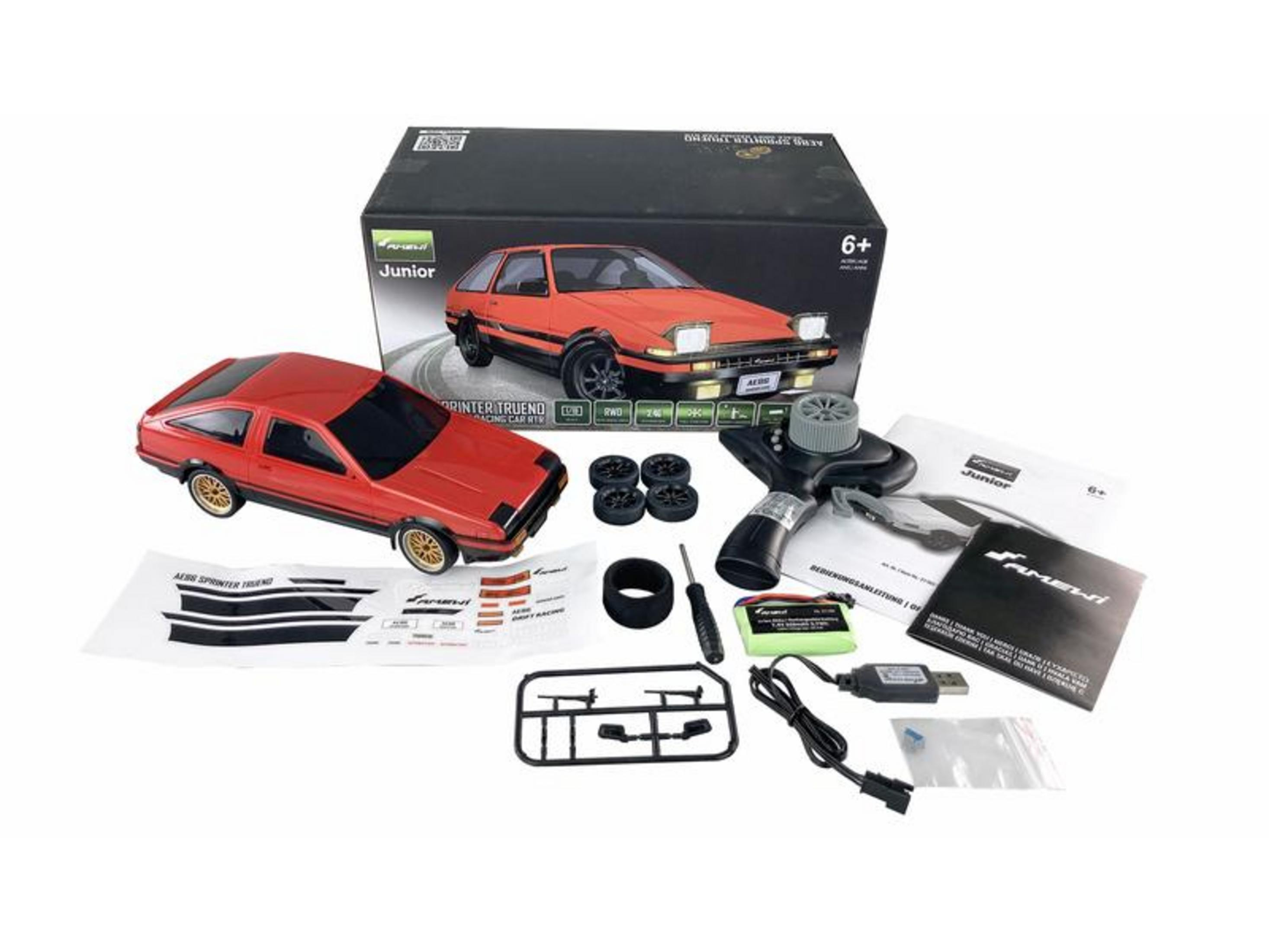 Ein rotes ferngesteuertes Auto, Verpackung und Zubehör auf weißem Hintergrund.