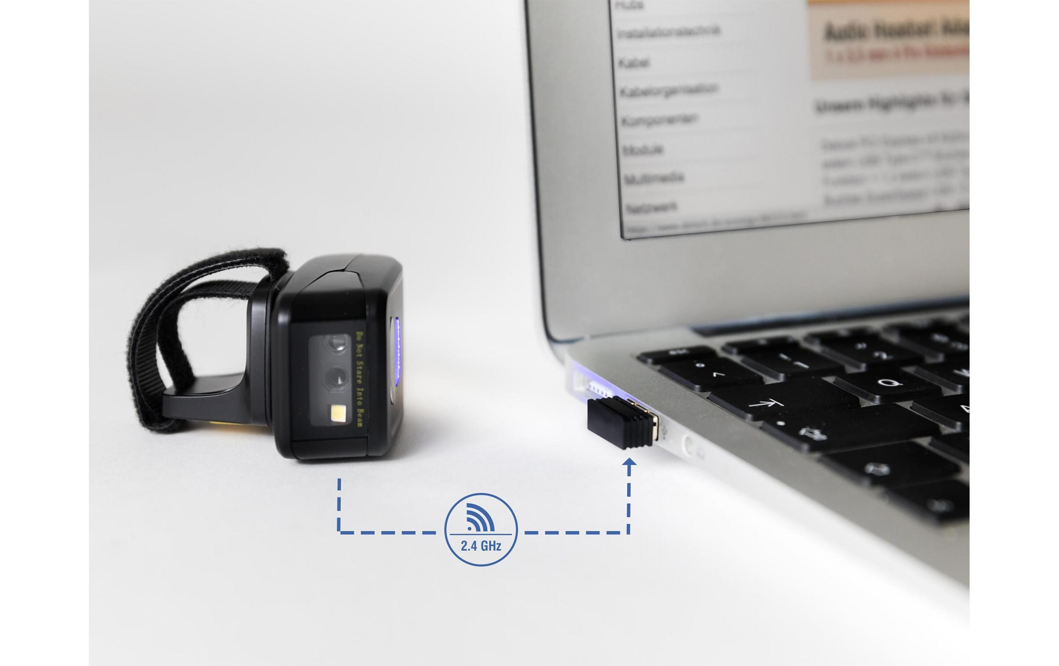 Uno scanner di codici a barre nero con cinturino da polso accanto a un laptop con dongle USB.