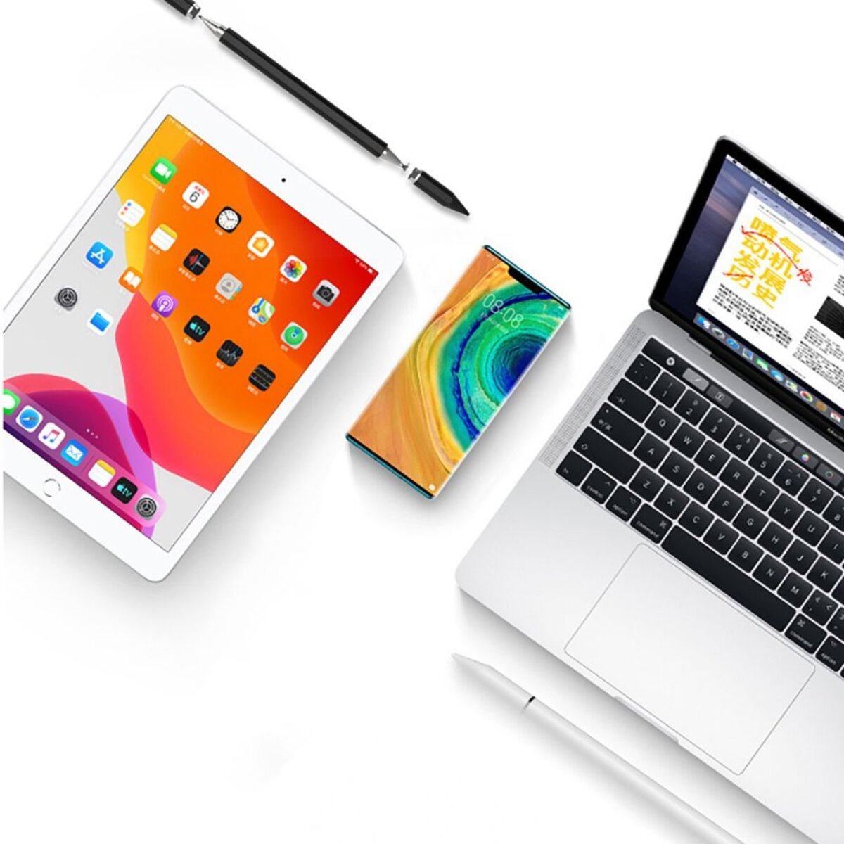 Ein Laptop, Tablet, Smartphone und zwei Stifte auf weißem Hintergrund.